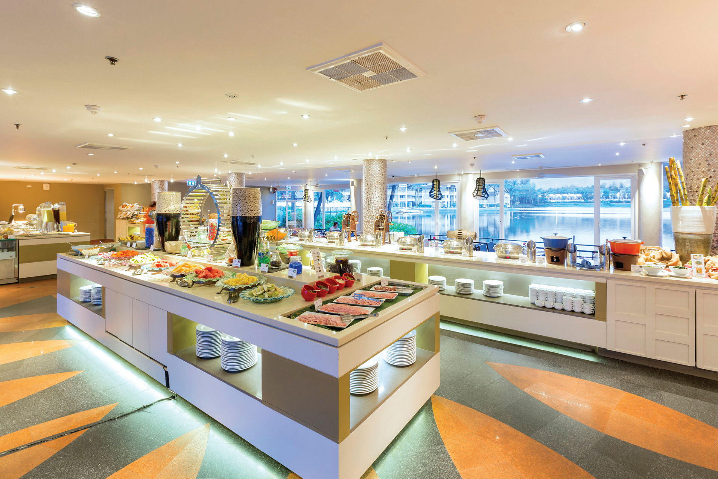 En rymlig bufférestaurang med olika maträtter och panoramautsikt över ett vattenområde. (AI-genererad text)