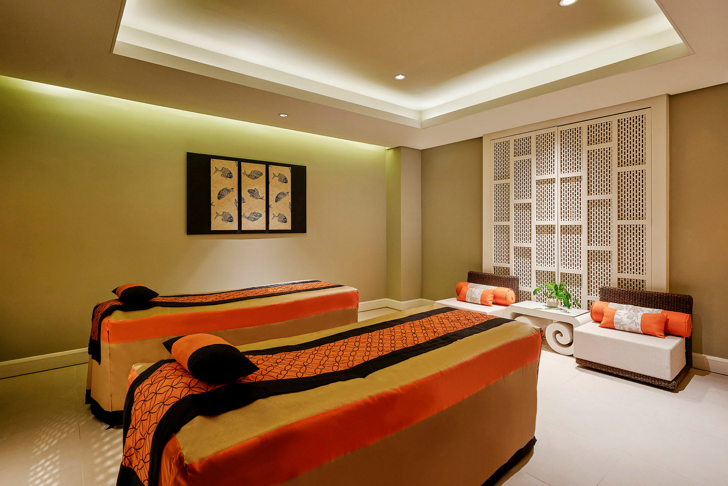 Ett spa-rum med två massagebänkar klädda i orange och beige tyg. (AI-genererad text)