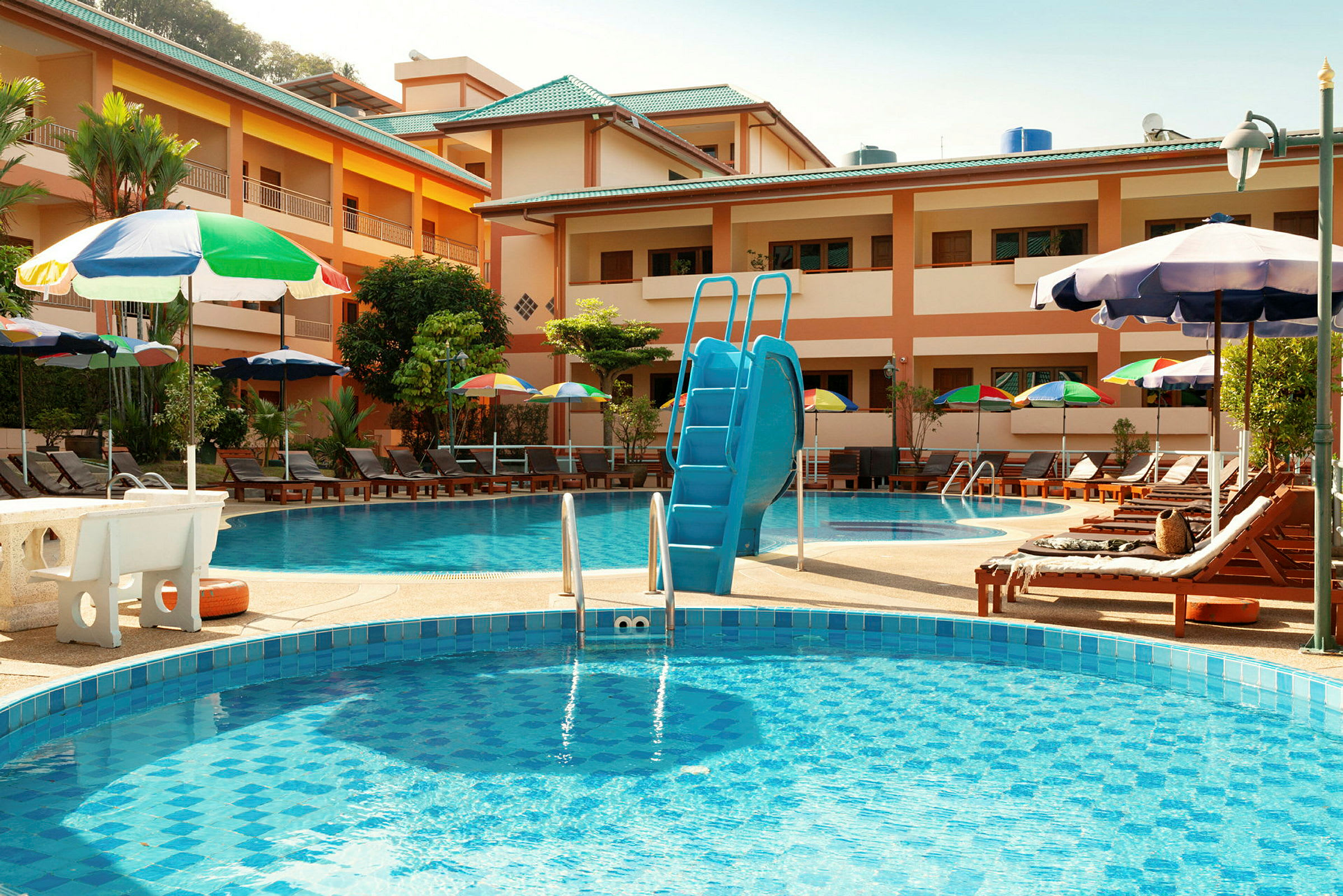 Hotellpoolområde med solstolar och parasoller. (AI-genererad text)