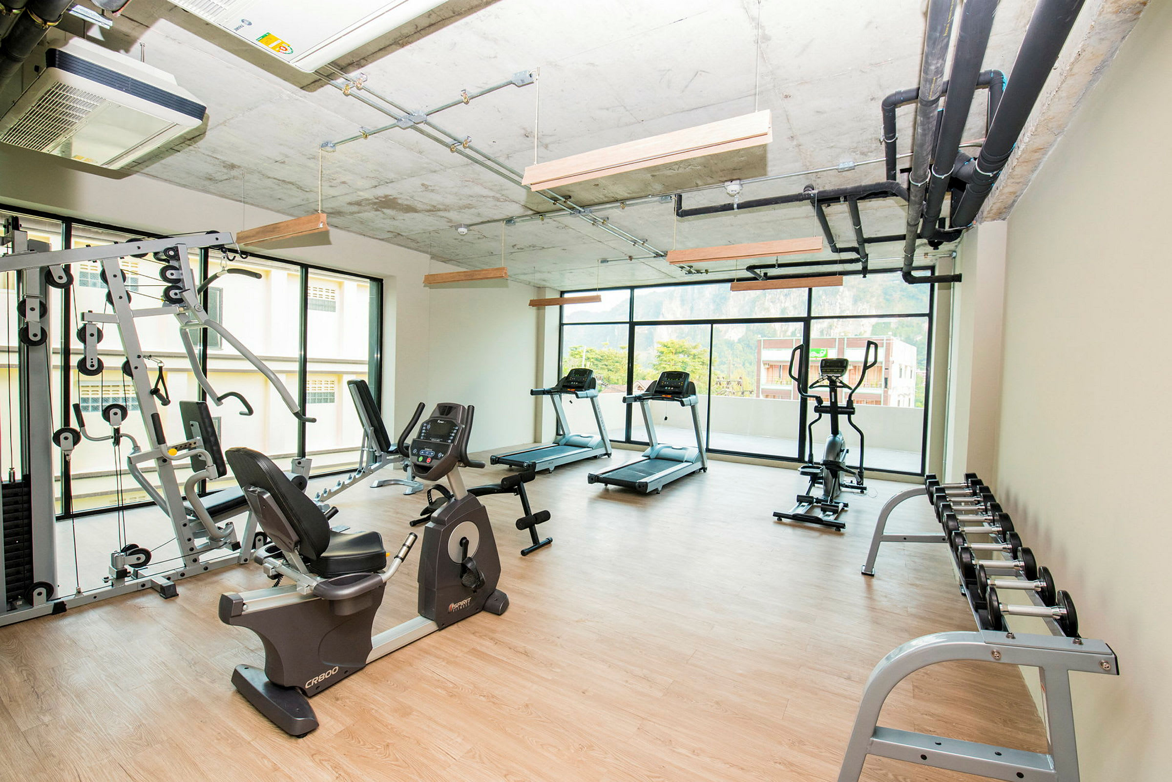 Ett ljust gym med träningsmaskiner, vikter och löpband. (AI-genererad text)