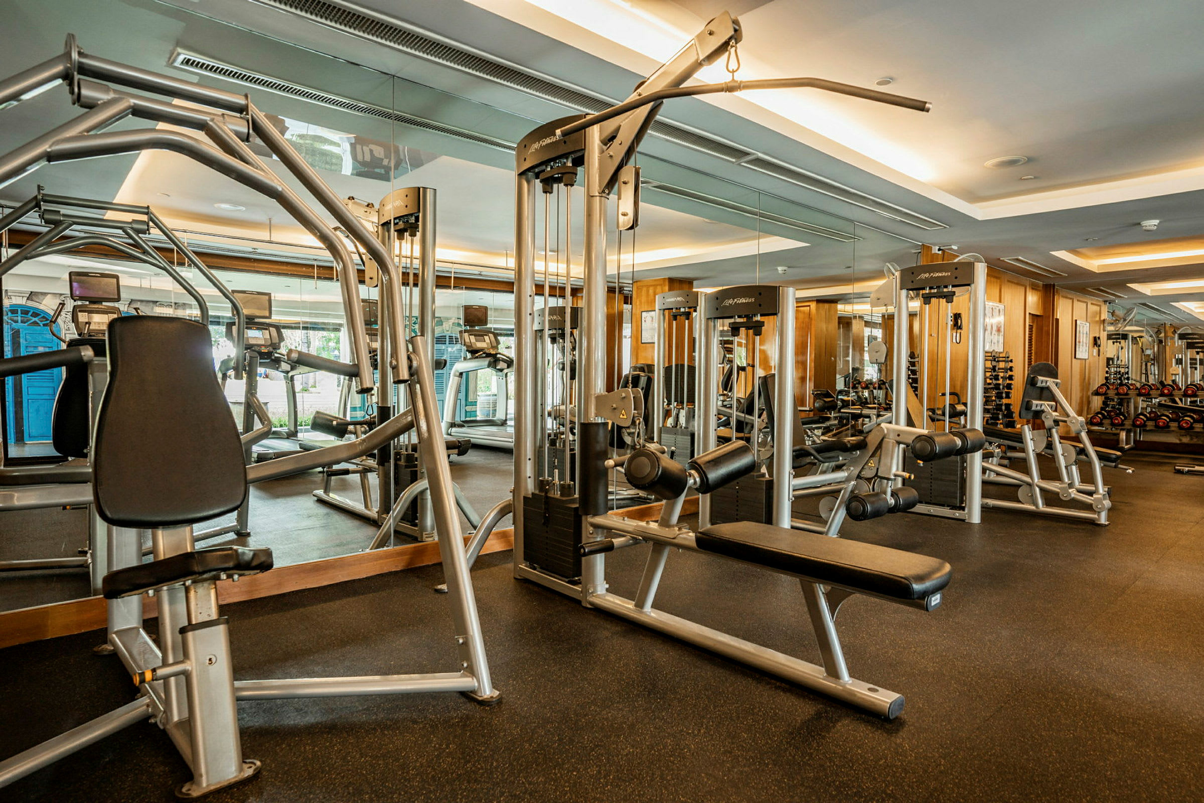 Ett gym med träningsmaskiner och spegelbeklädda väggar. (AI-genererad text)