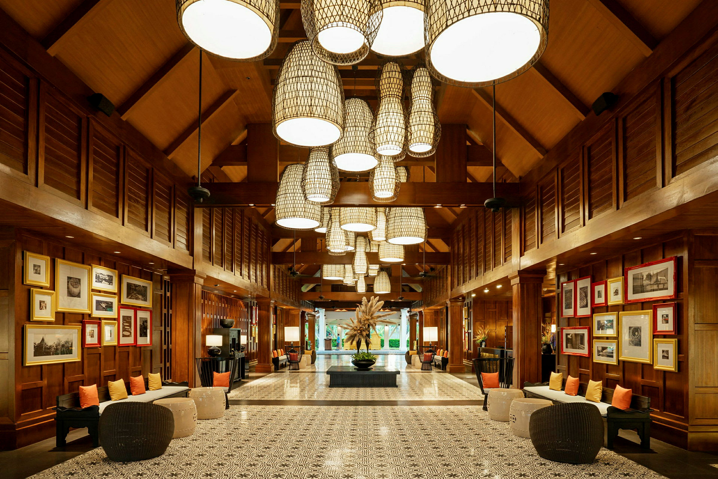 Bild av en elegant hotellobby med träpaneler, dekorativa ljusarmaturer i taket och konstverk på väggarna. (AI-genererad text)
