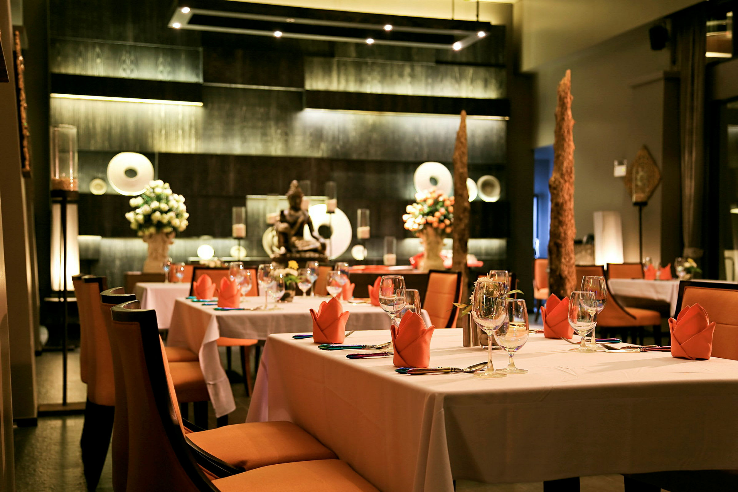 Ett stilfullt inrett restaurang med dukade bord och dekorationer. (AI-genererad text)