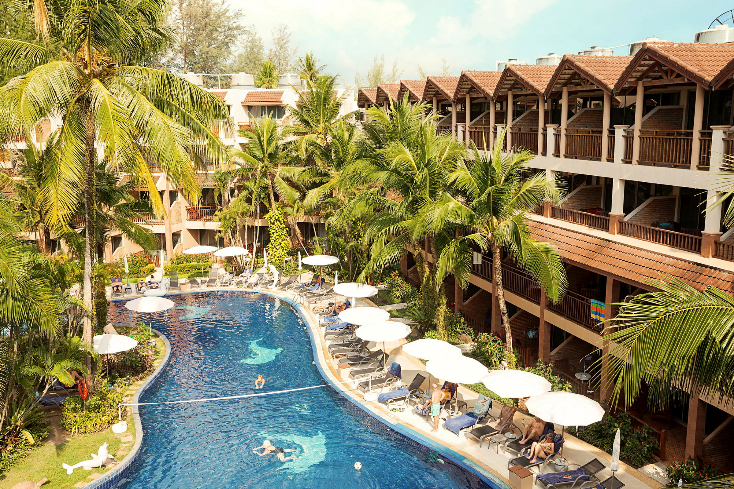 En hotellpool omgiven av solstolar, parasoller och grönska. (AI-genererad text)
