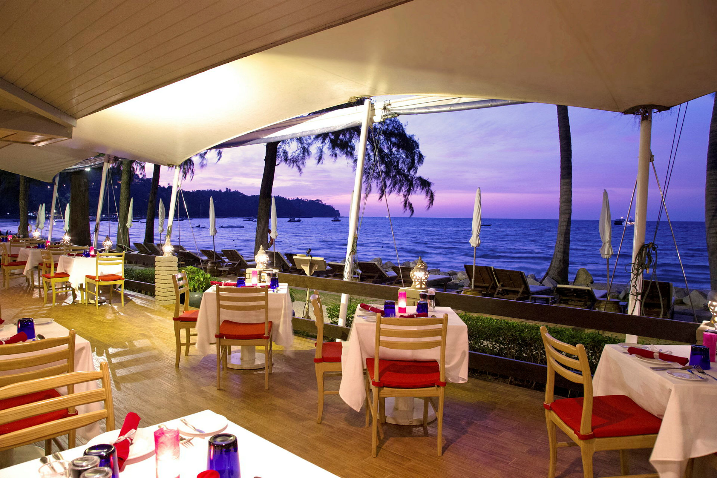 Restaurang med uteservering nära stranden vid solnedgången. (AI-genererad text)