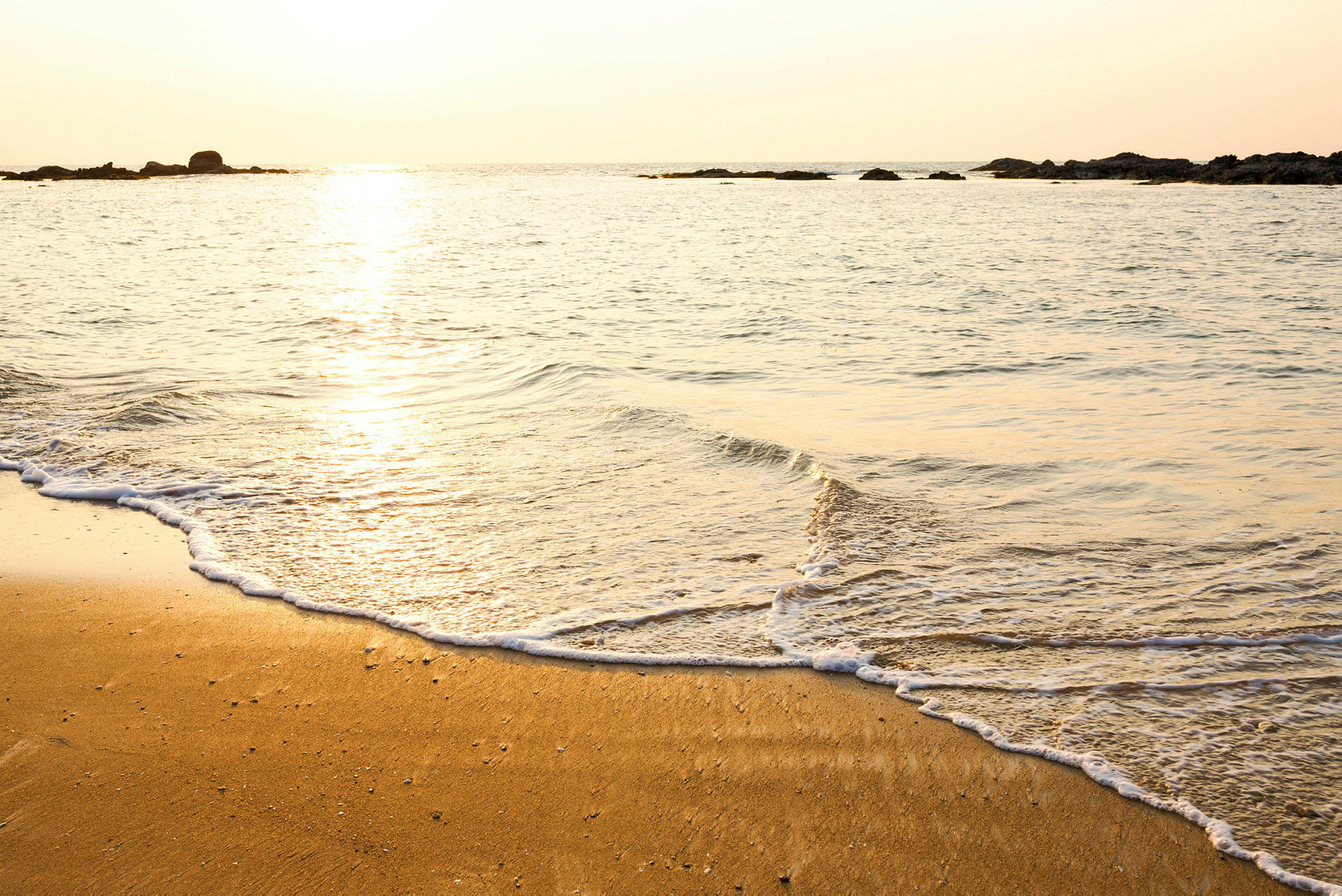 En strand vid havet med solnedgång. (AI-genererad text)