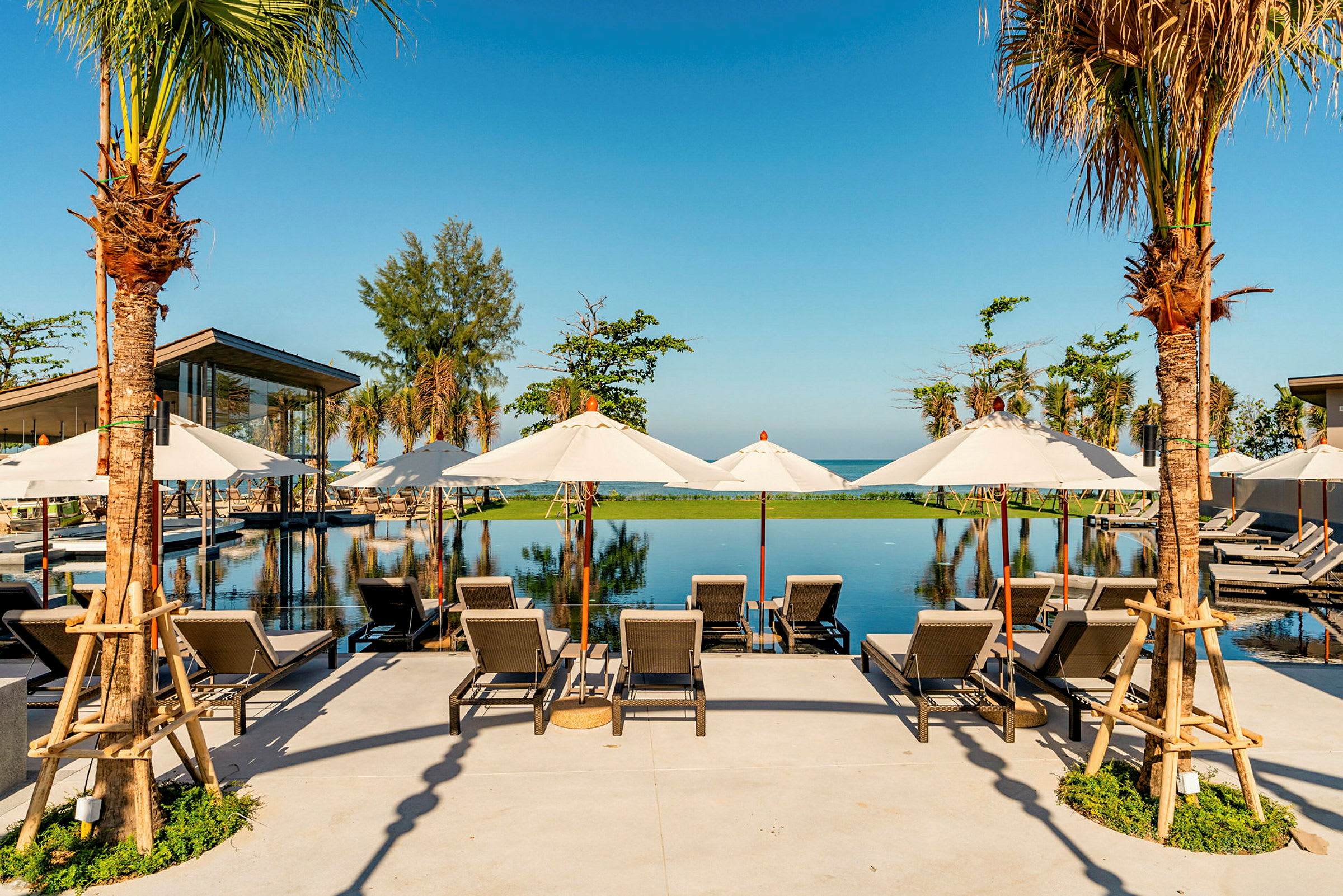 Solstolar och parasoller vid en infinitypool med utsikt över havet. (AI-genererad text)