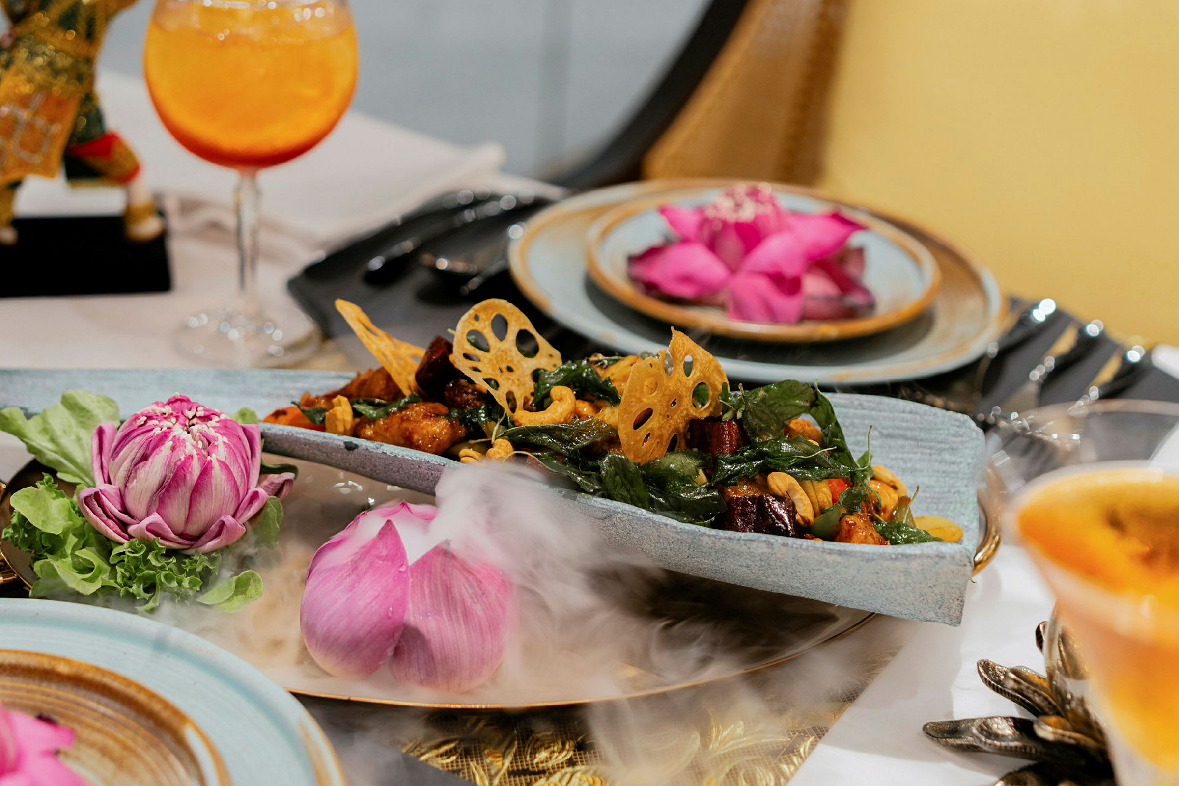 En elegant servering med maträtt och dekorativa blommor på ett bord. (AI-genererad text)