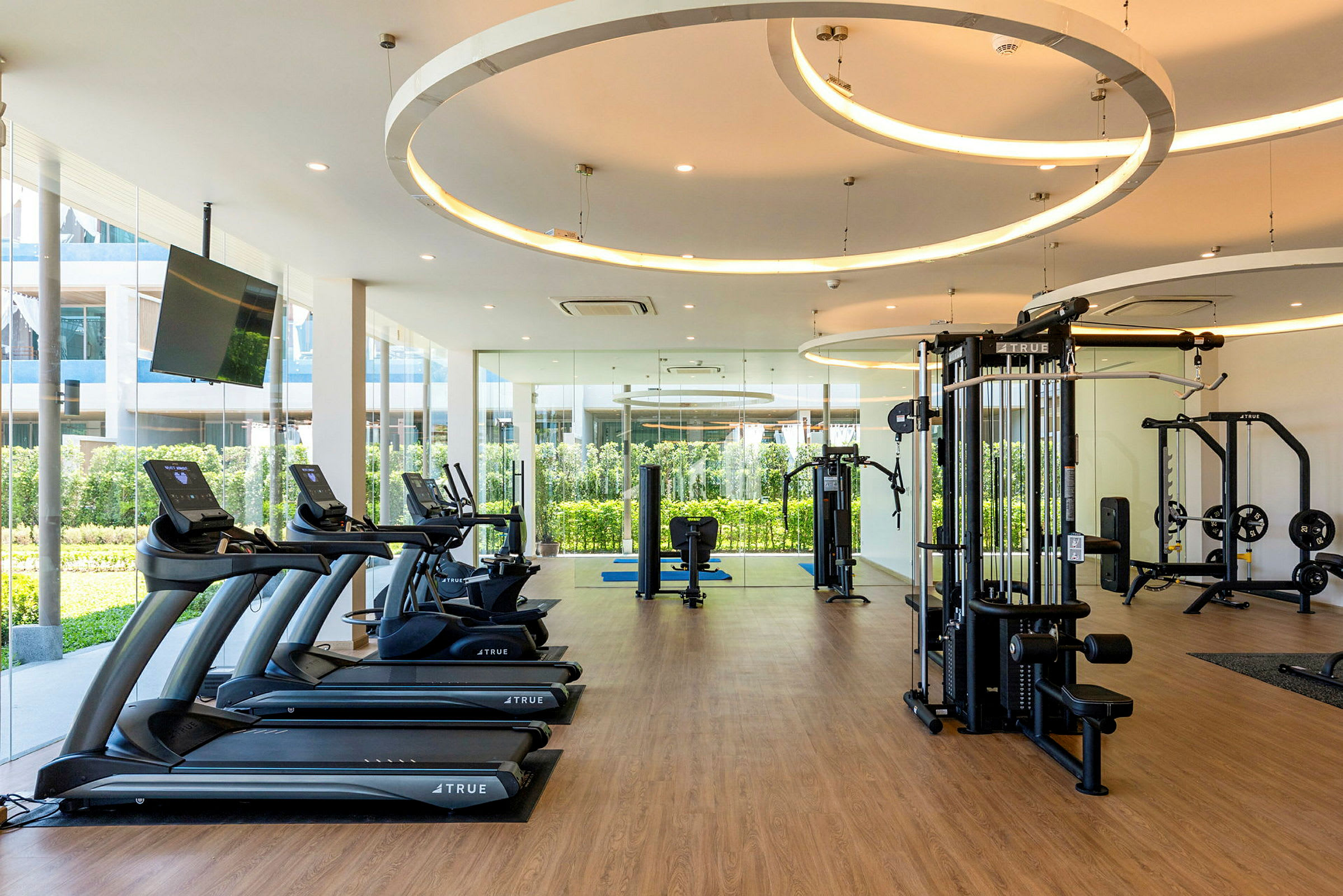 Moderna gymmaskiner i en ljus träningslokal med glasväggar. (AI-genererad text)