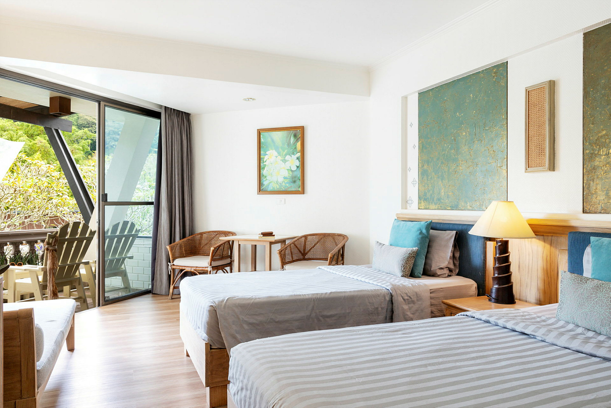 Hotellrum med två sängar, sittmöbler samt en balkong med utsikt. (AI-genererad text)
