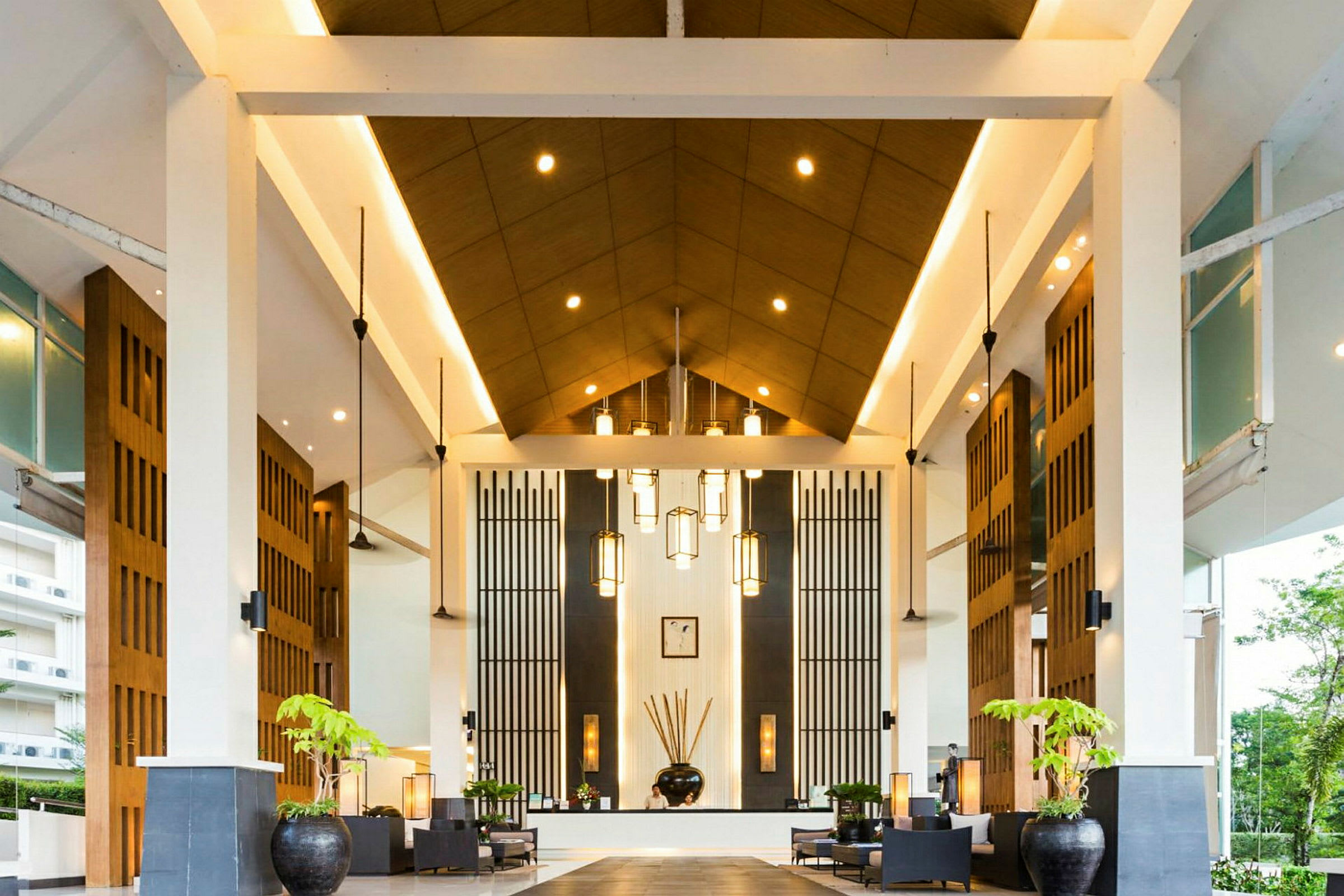 En hotellobby med högt tak, modern design och dekorativa lampor. (AI-genererad text)
