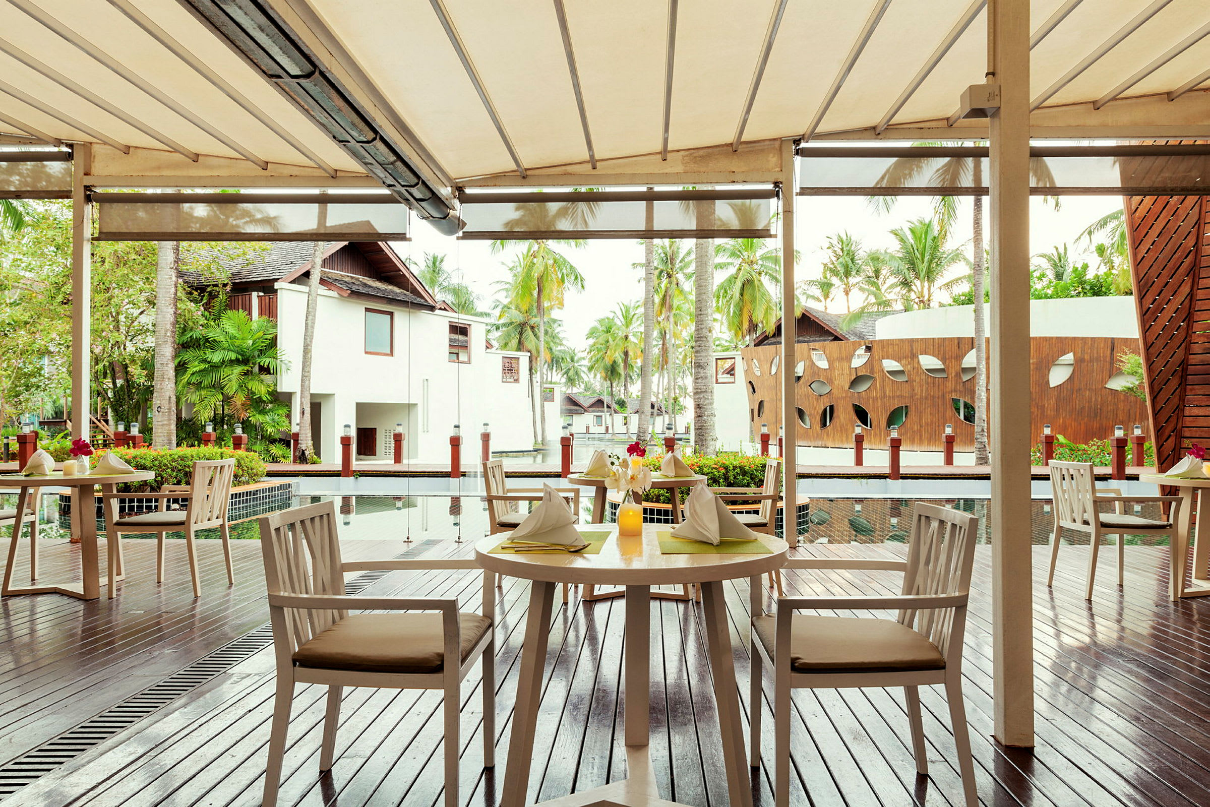 Utomhusrestaurang med dukade bord och utsikt över en byggnad med dekorativa detaljer. (AI-genererad text)