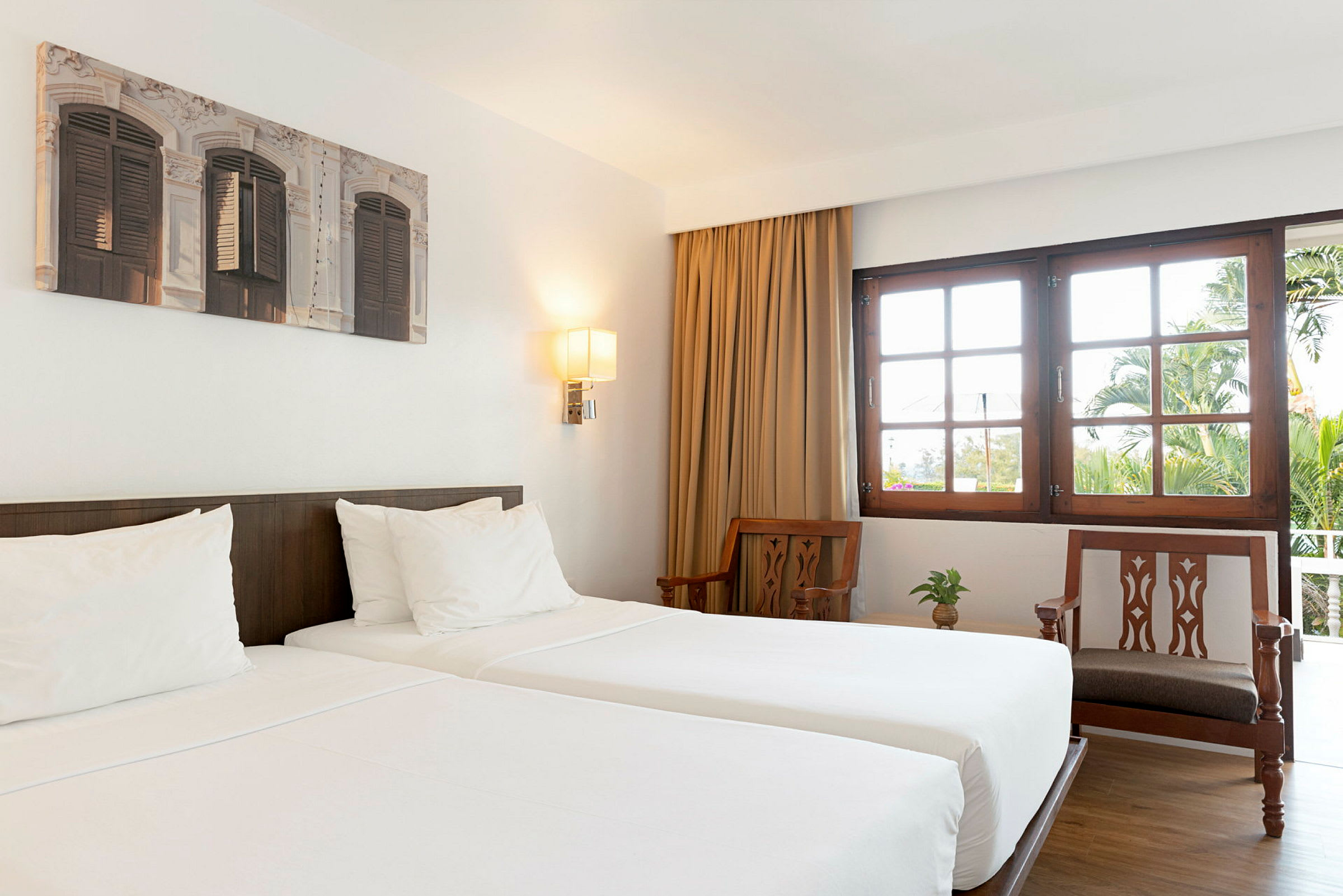 Hotellrum med två enkelsängar och möbler i ljust trä. (AI-genererad text)