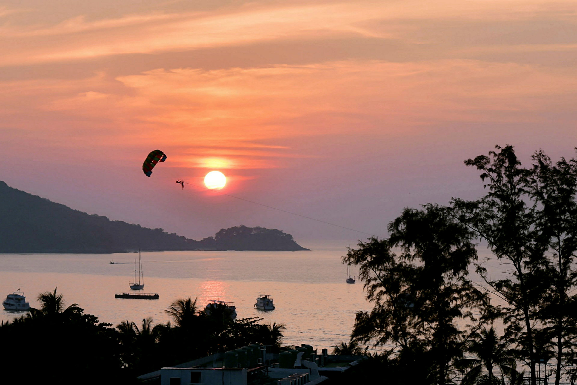 Person som utför parasailing över havet vid solnedgång. (AI-genererad text)