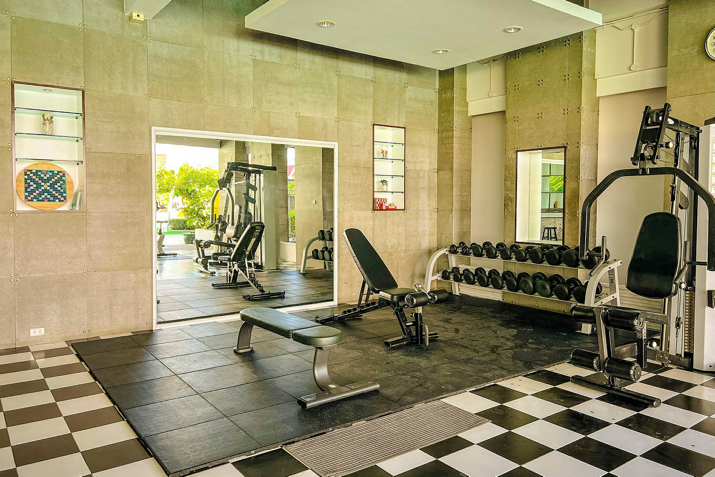 Bild av ett gym med träningsmaskiner, bänkar och hantlar. (AI-genererad text)