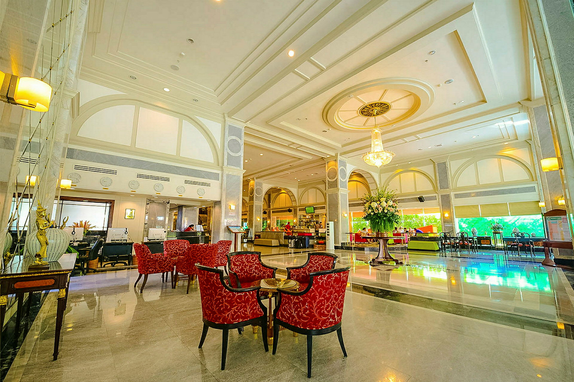 Elegant hotellobby med röda sittmöbler och en stor blomsterdekoration. (AI-genererad text)
