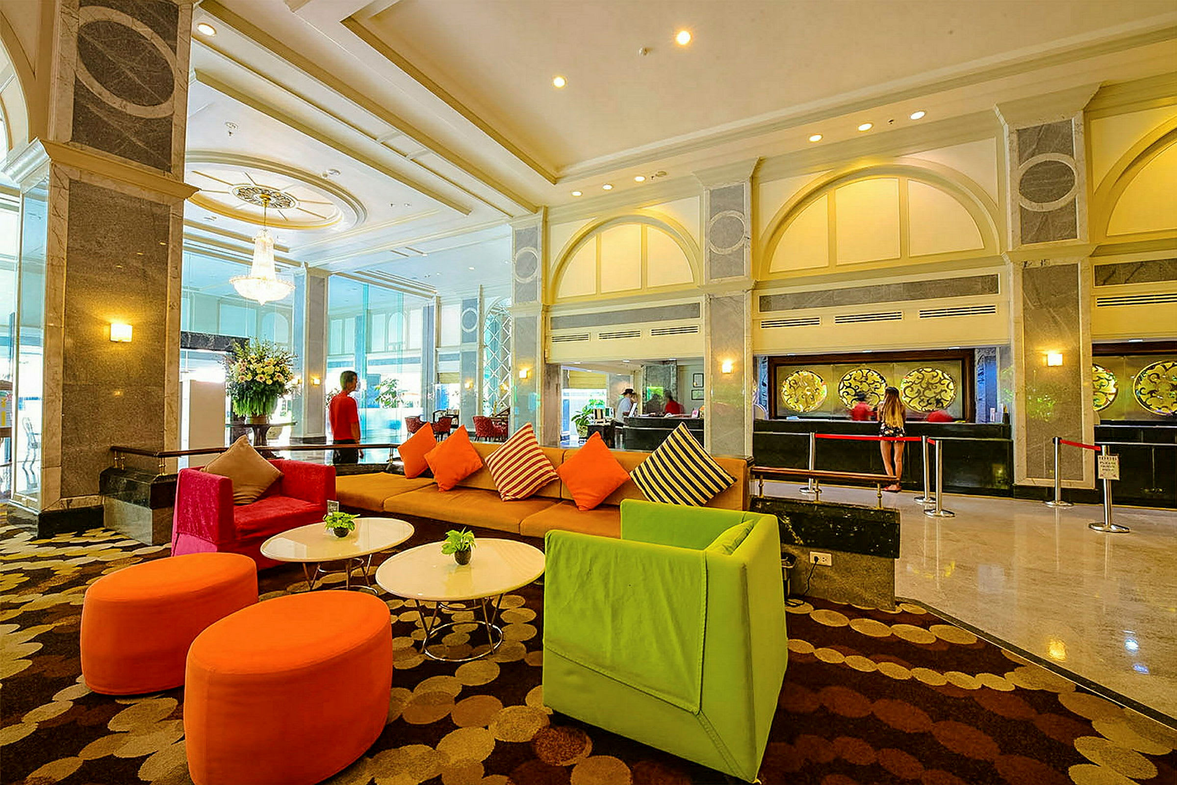 Interiör av ett rymligt hotelllobby med färgglada sittmöbler och reception i bakgrunden. (AI-genererad text)