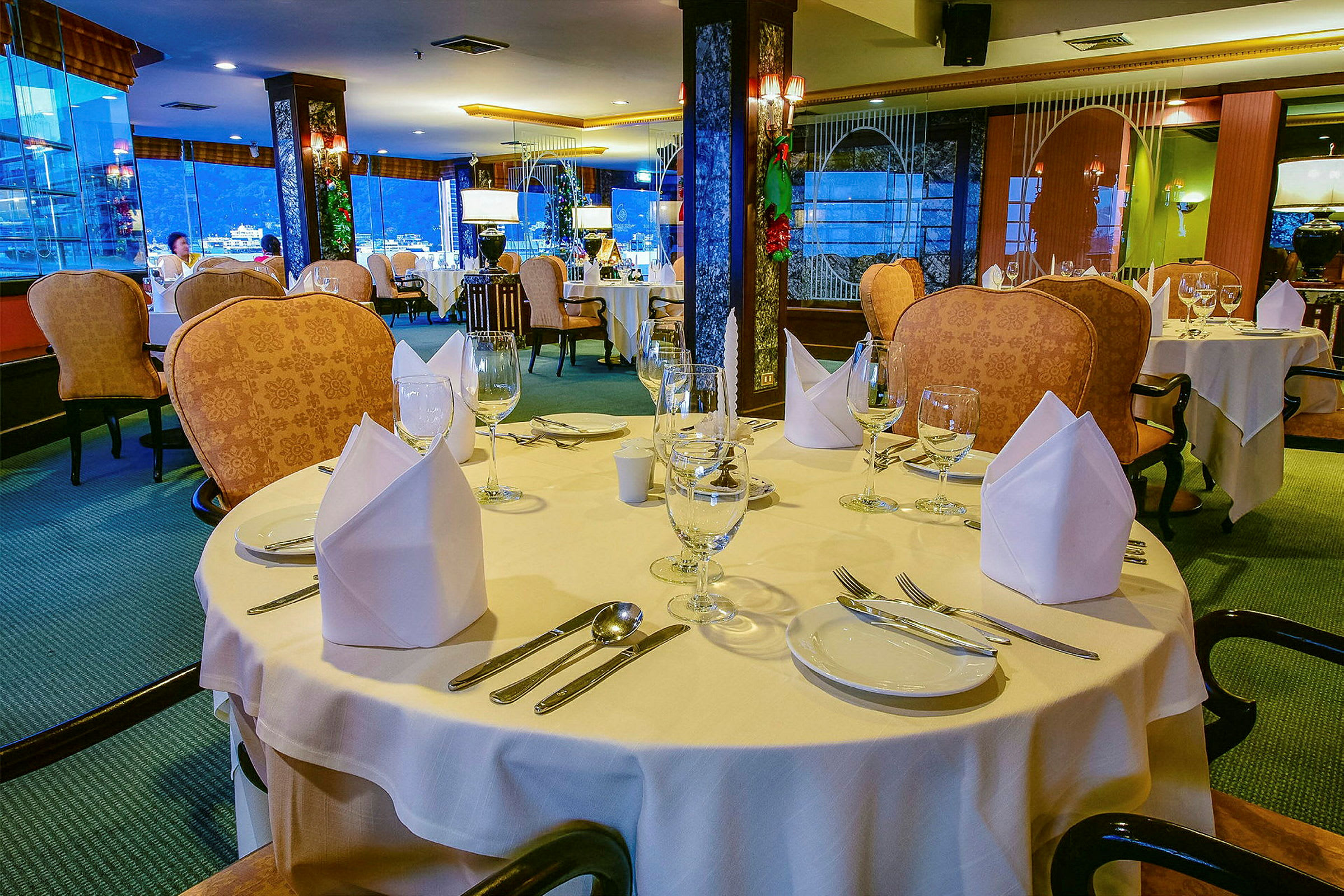Ett elegant bord med vit duk, vinglas och bestick i en fin restaurang. (AI-genererad text)