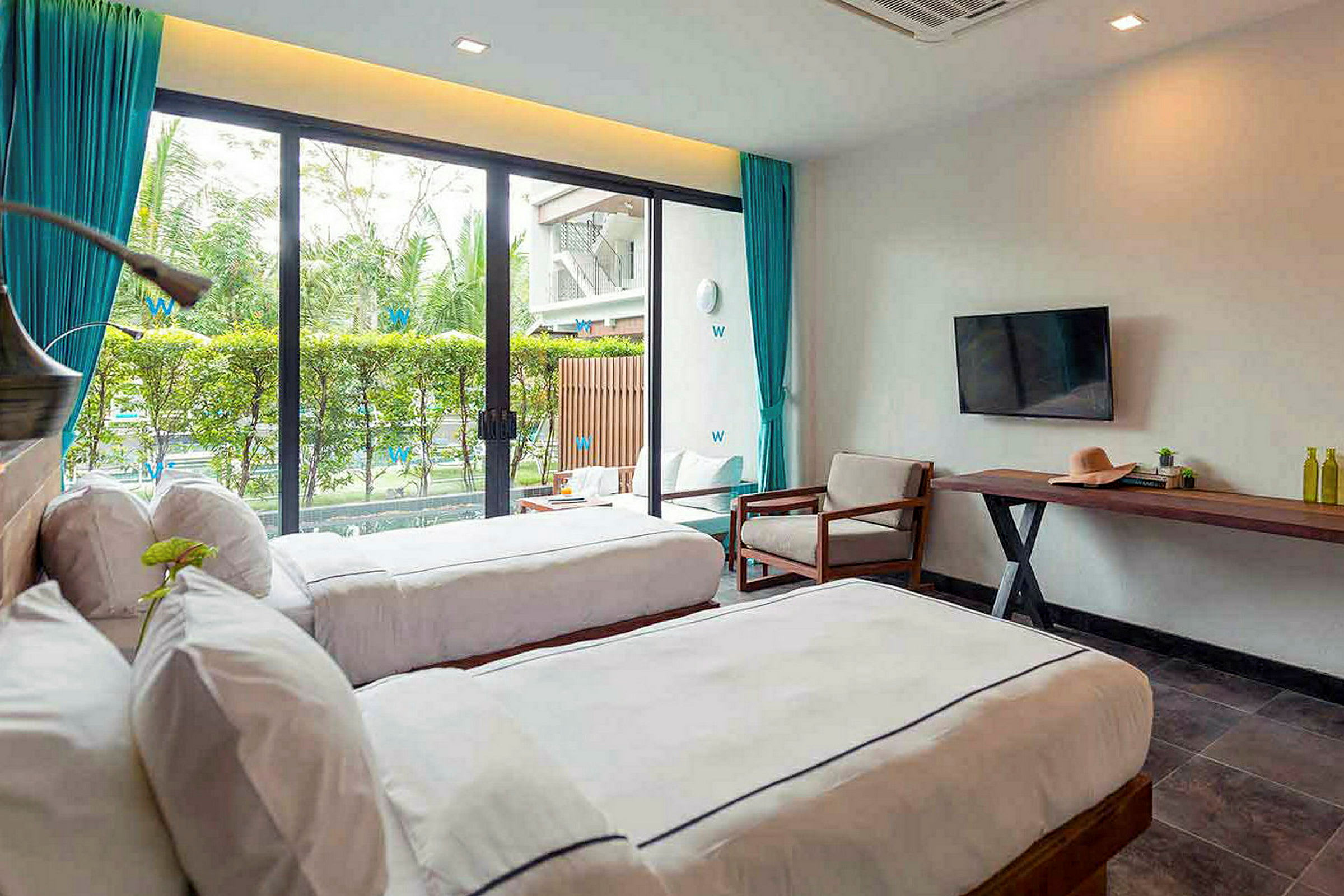 Moderna hotellrum med två enkelsängar och en rymlig terrass utanför fönstret. (AI-genererad text)