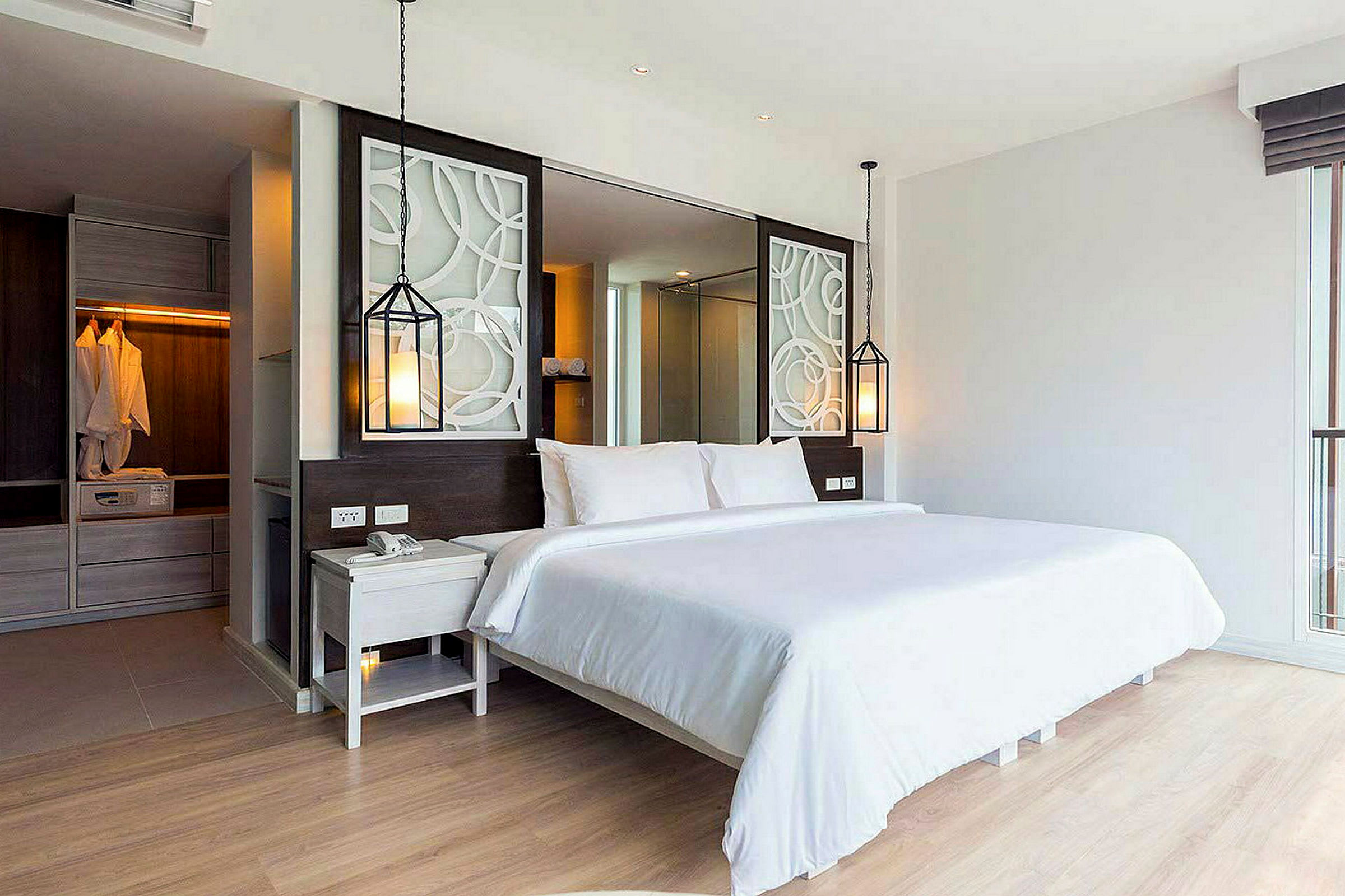 En modern hotellsvit med en bekväm dubbelsäng, dekorativa element och en garderob i bakgrunden. (AI-genererad text)
