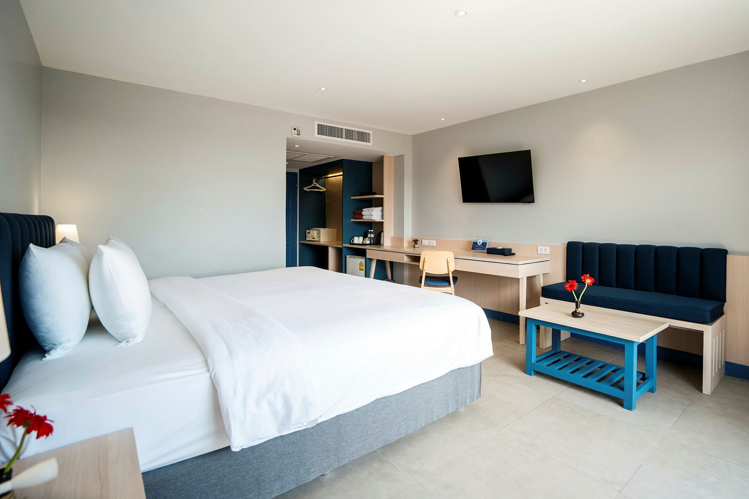 Ett modernt hotellrum med en dubbelbädd, soffa, och skrivbord. (AI-genererad text)