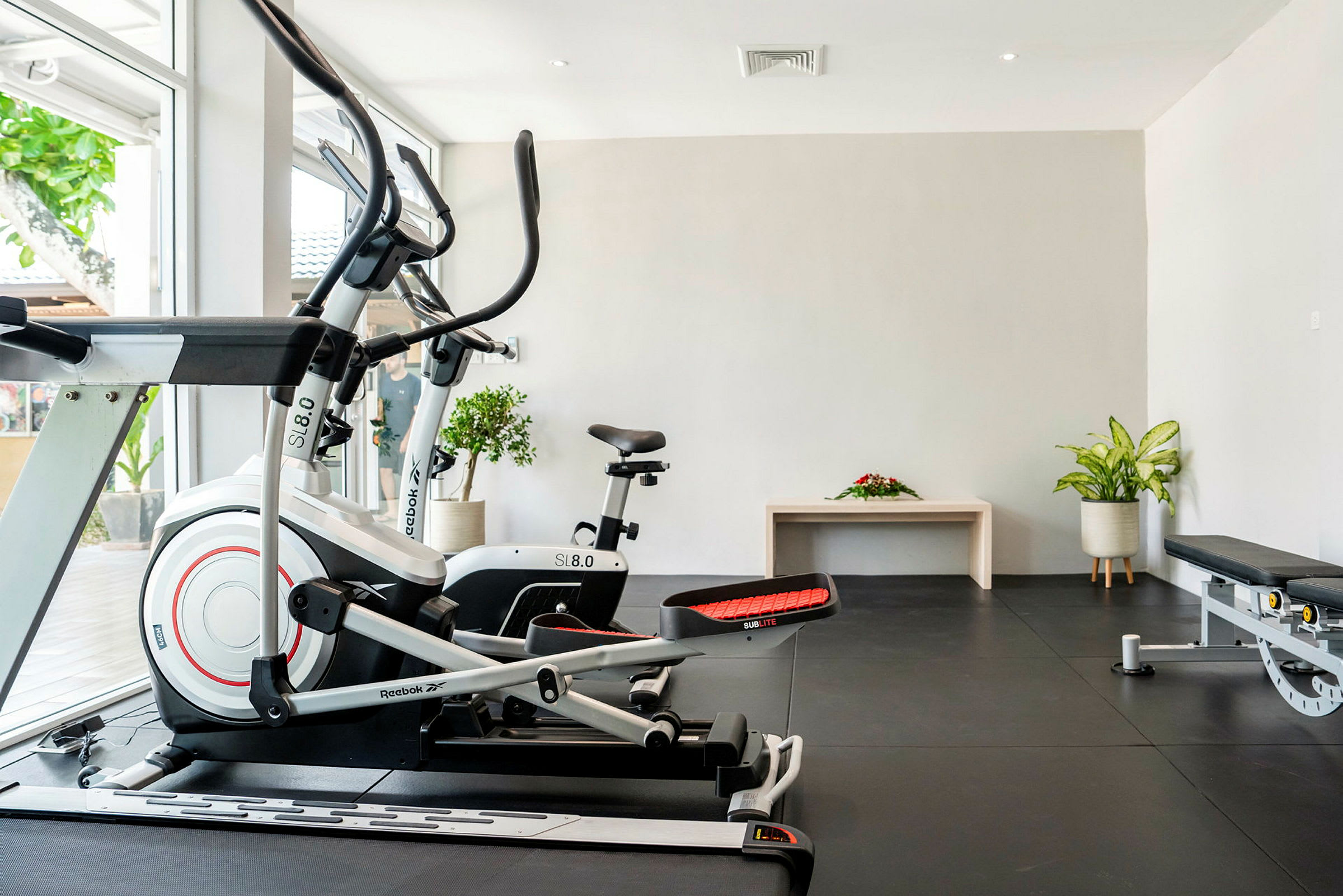 Gym med träningsmaskiner och växter. (AI-genererad text)