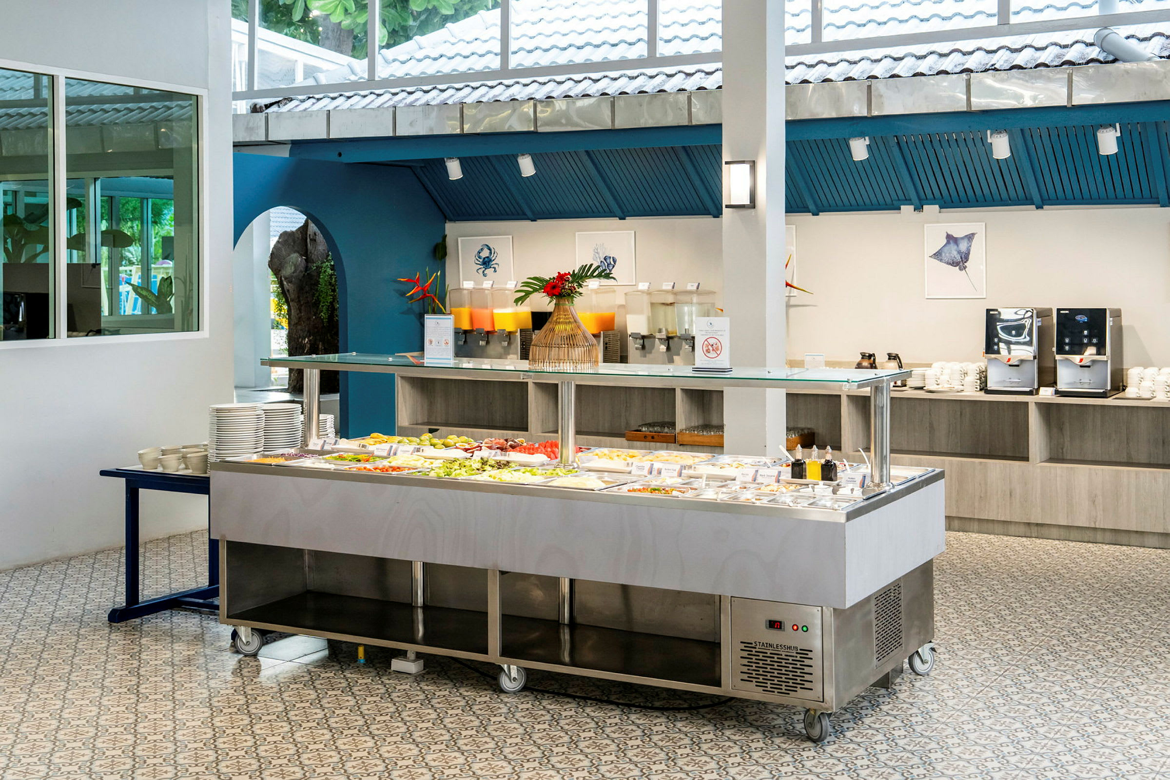 Buffé med sallad och dryckesstation i ljust rum. (AI-genererad text)