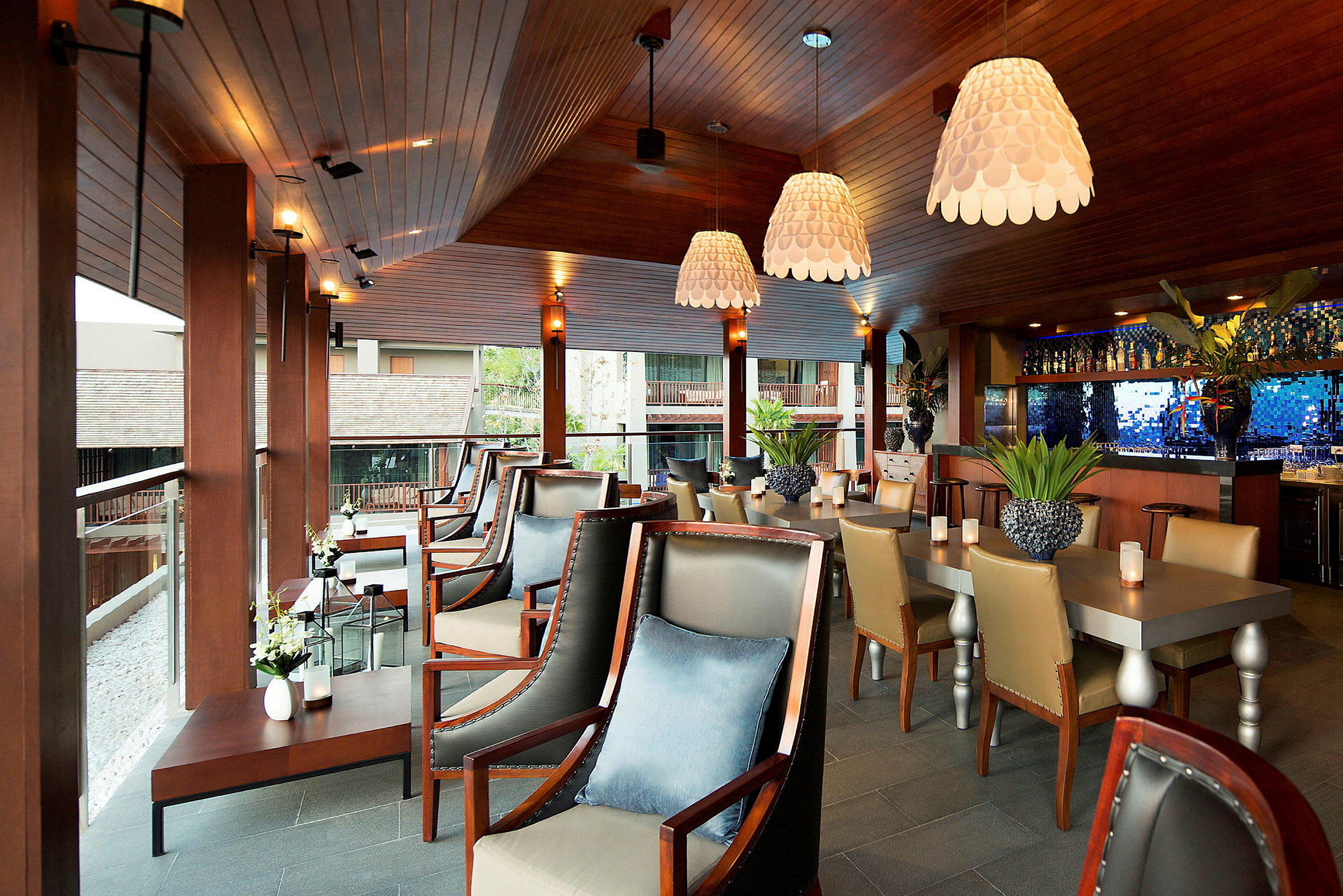 Interiör av en modern restaurang eller bar med elegant träinredning, bekväma sittmöbler och dekorativa lampor. (AI-genererad text)