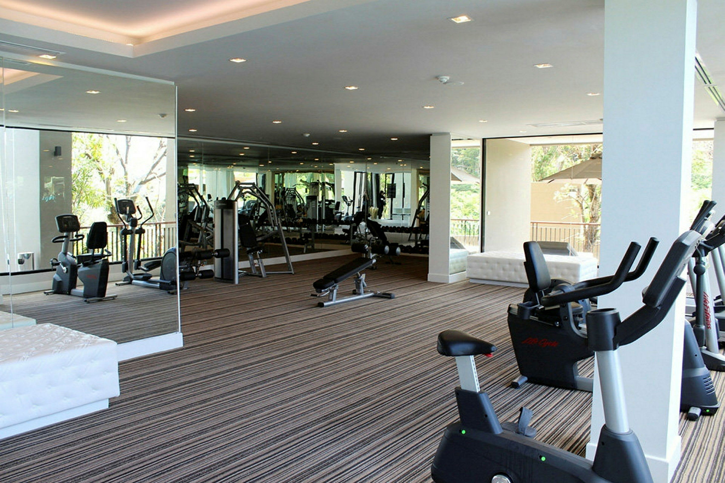 Gym med träningsutrustning och spegelväggar. (AI-genererad text)