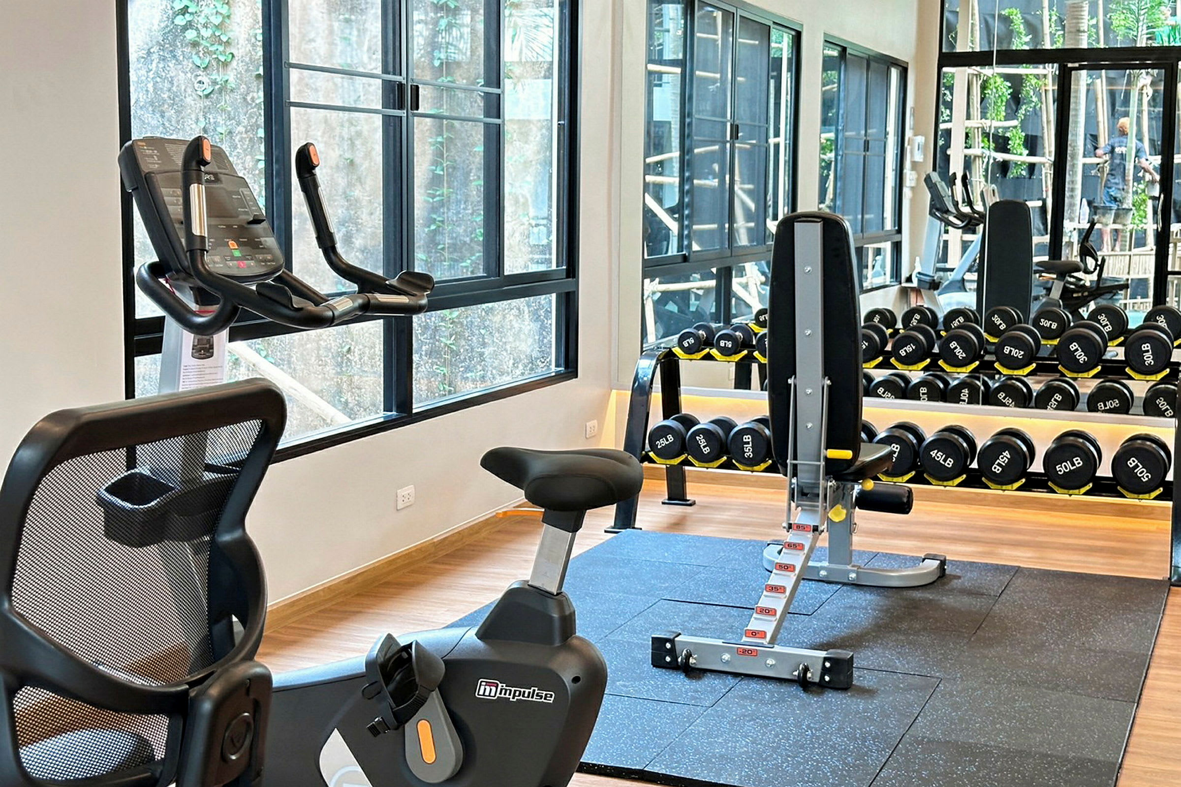 Interiörbild av ett gym med träningsutrustning såsom motionscykel och hantlar. (AI-genererad text)