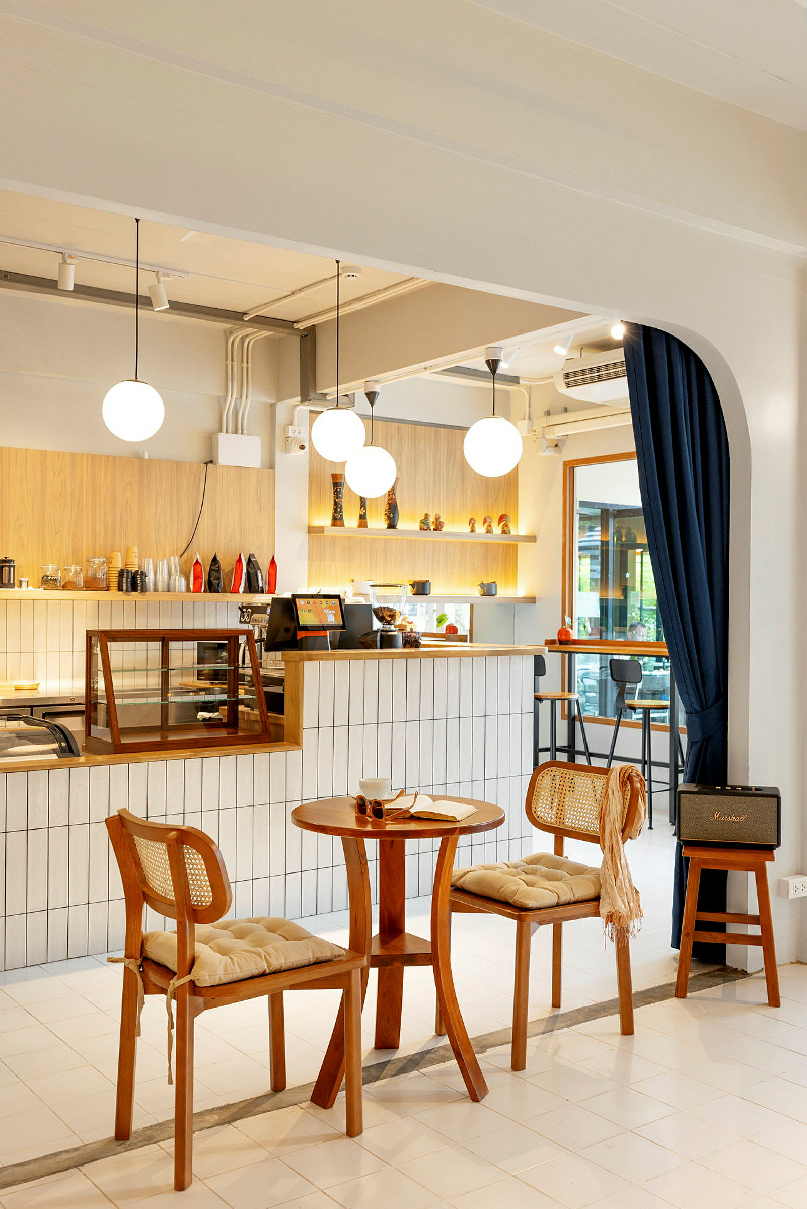 Bild av ett inrett café med träbord och stolar samt upplysta hyllor. (AI-genererad text)