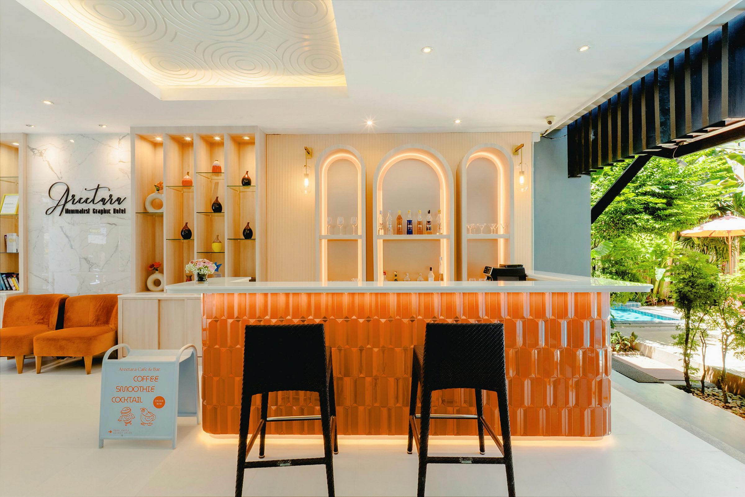 Ett smakfullt inrett café eller bar med orange detaljer och modern belysning. I bakgrunden syns hyllor med dekorativa föremål och flaskor. (AI-genererad text)