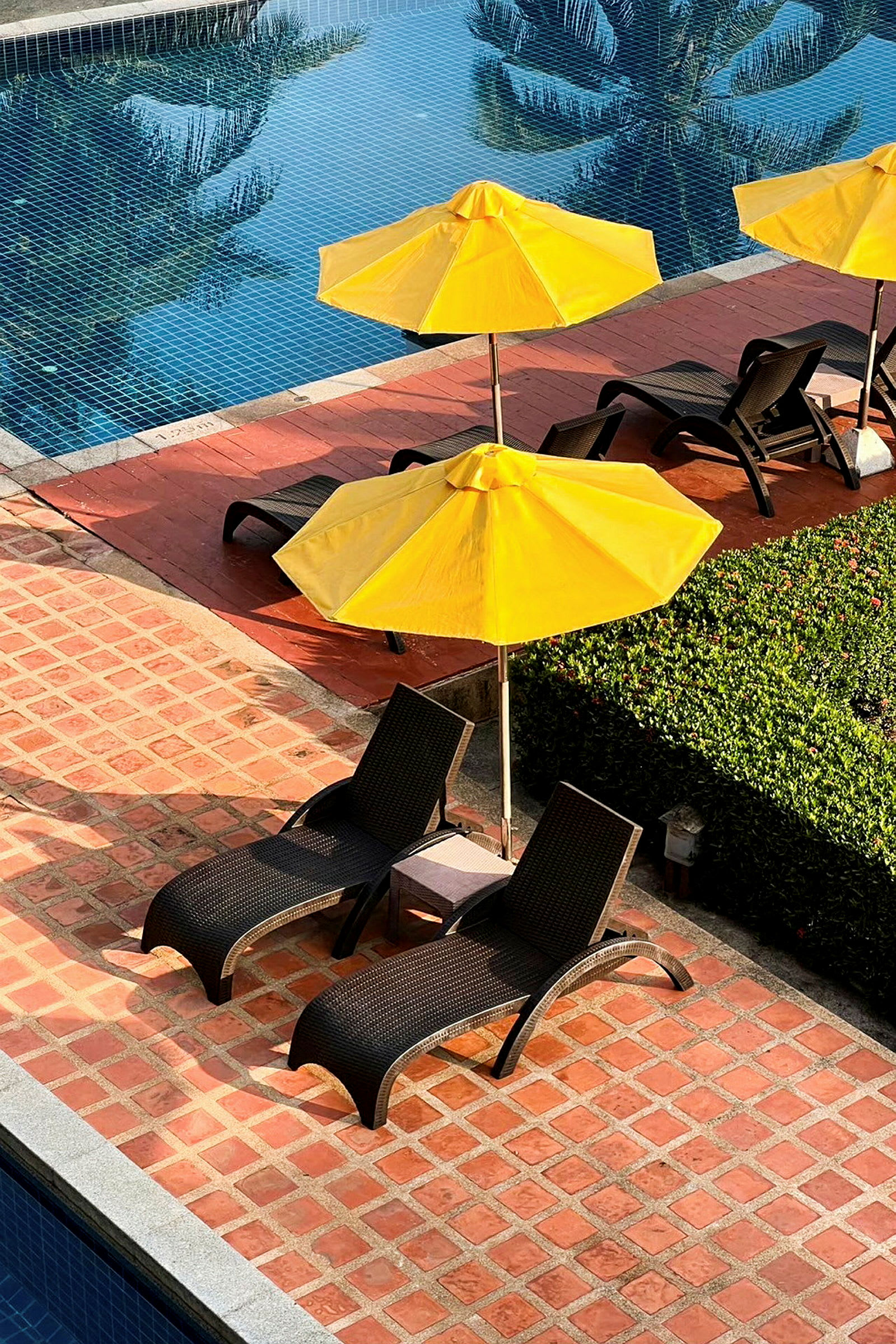 Loungeplats vid pool med solstolar och parasoller. (AI-genererad text)