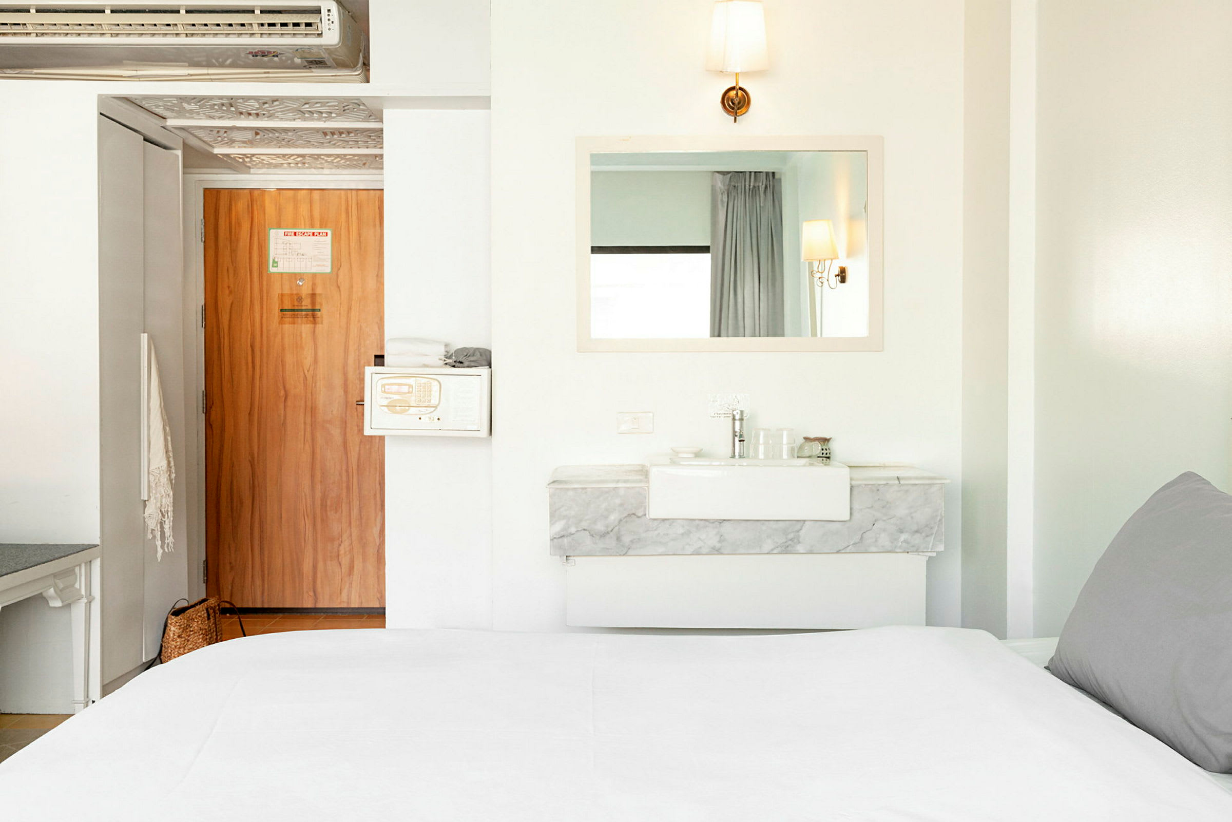 Standard hotellrum med en spegel, trädörr och säng. (AI-genererad text)