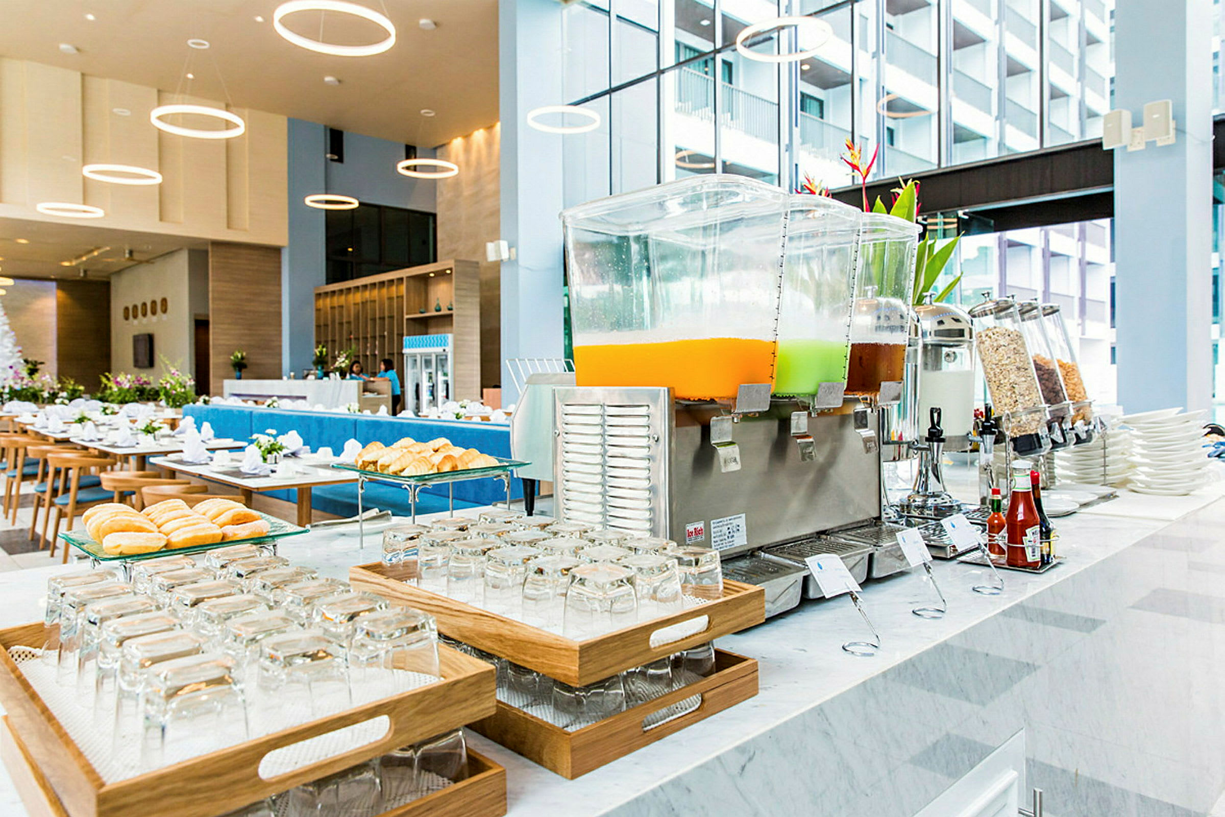 Frukostbuffé med juicemaskiner och bakverk vid ett modernt hotell. (AI-genererad text)