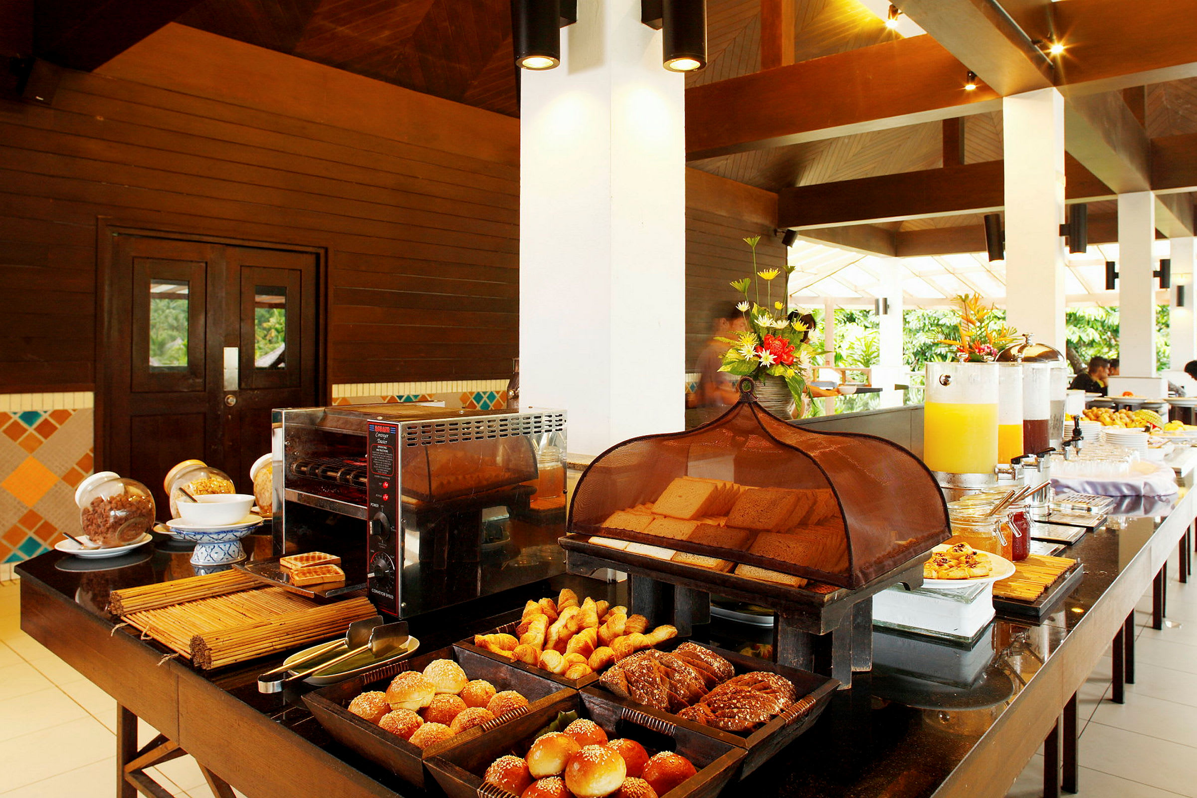 Hotellfrukost med bröd, croissanter och drycker på ett buffébord. (AI-genererad text)