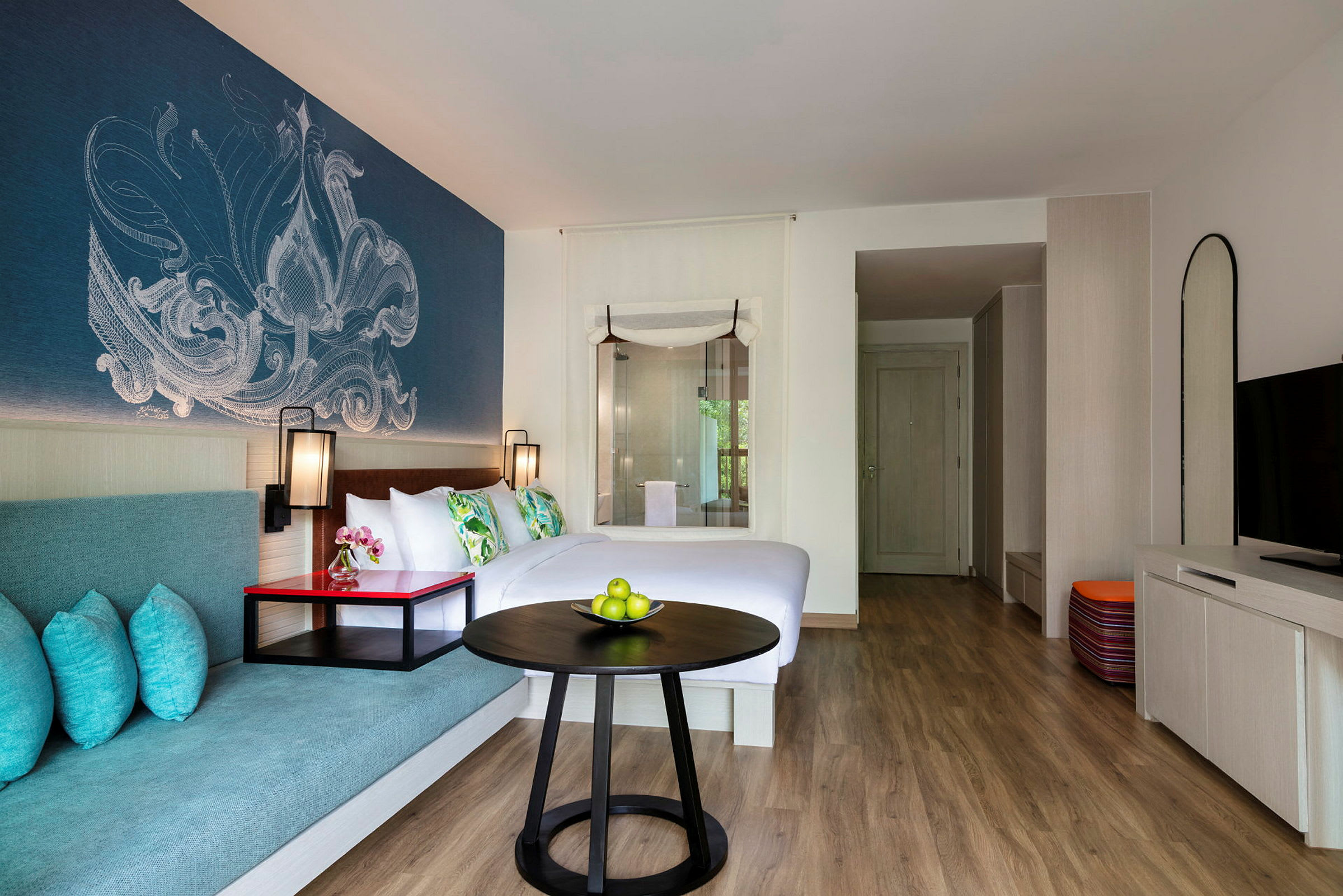Ett hotellrum med en dubbelsäng, sittplats och dekorativ väggdesign. (AI-genererad text)