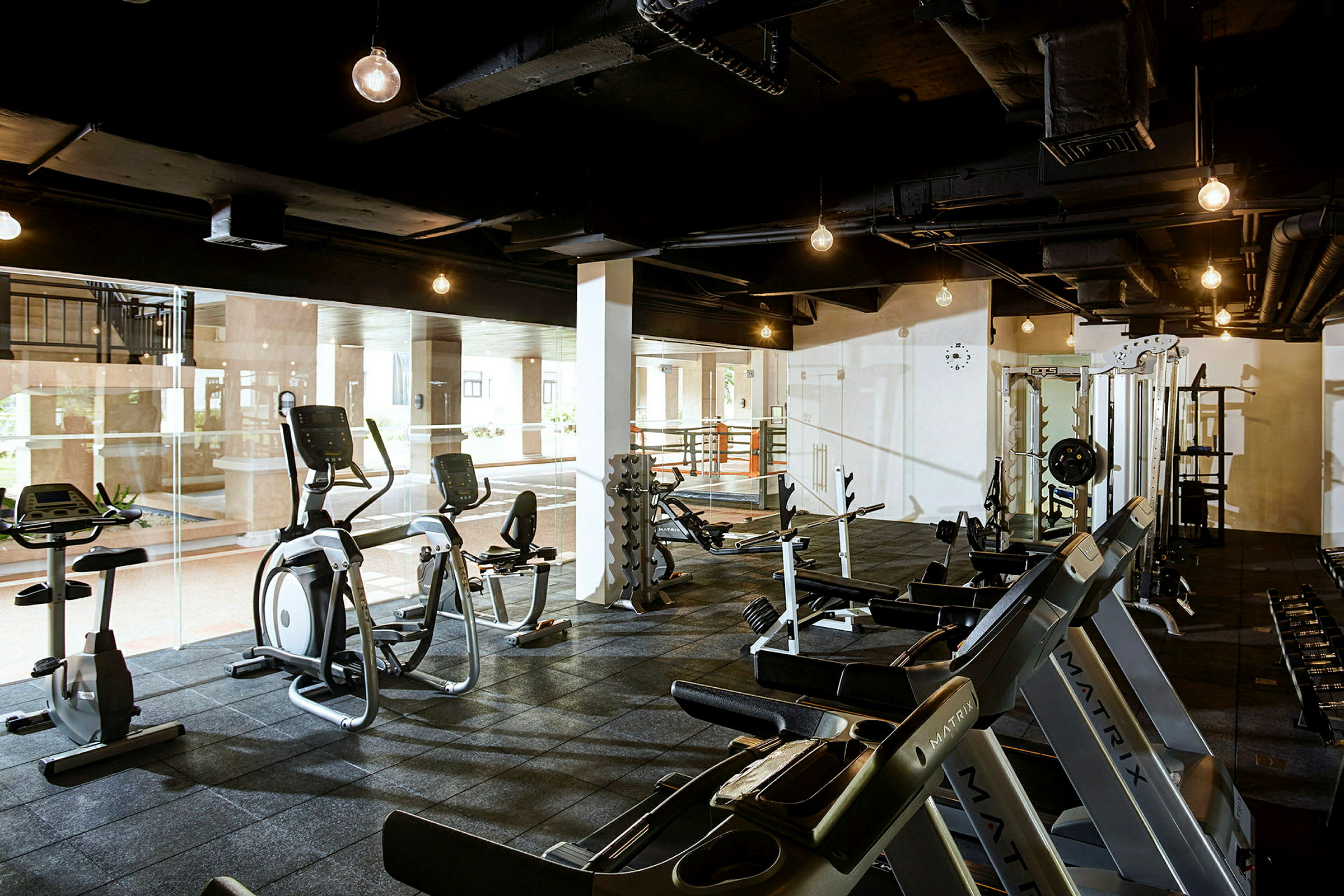 Ett gym med träningsmaskiner, fria vikter och träningsutrustning. (AI-genererad text)