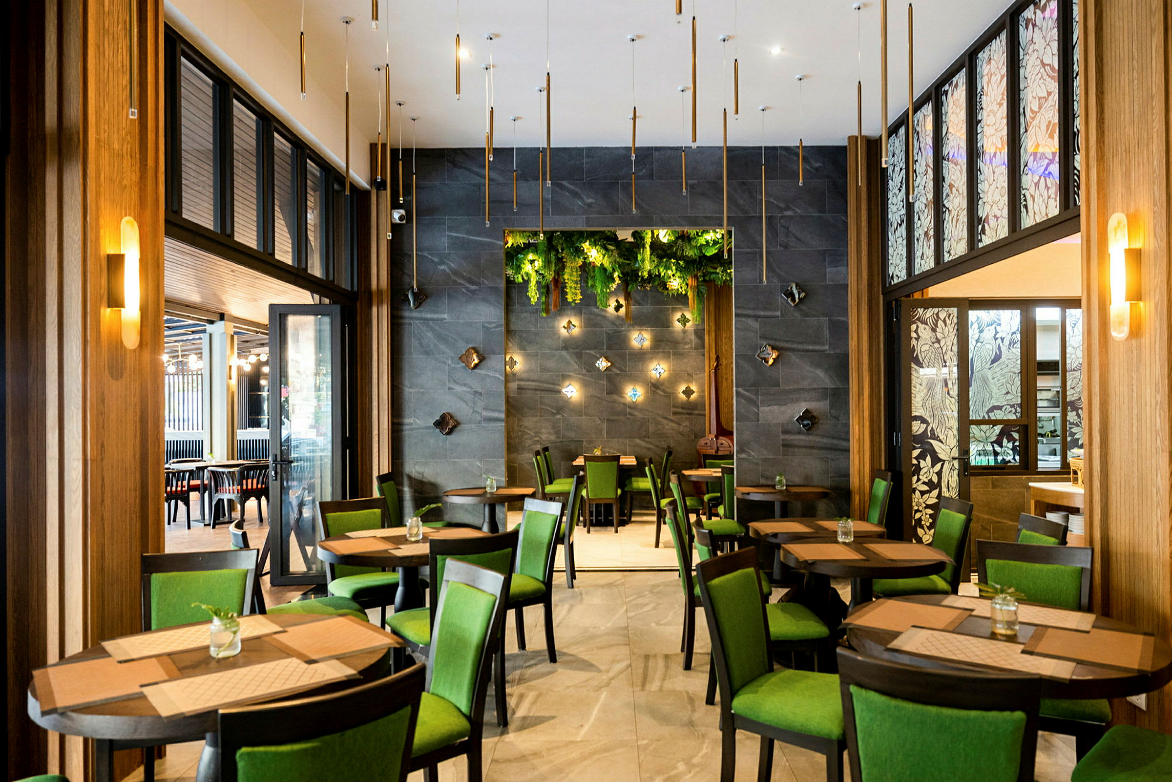 Restaurang med bord och stolar, gröna inslag och dekorativa väggdetaljer. (AI-genererad text)