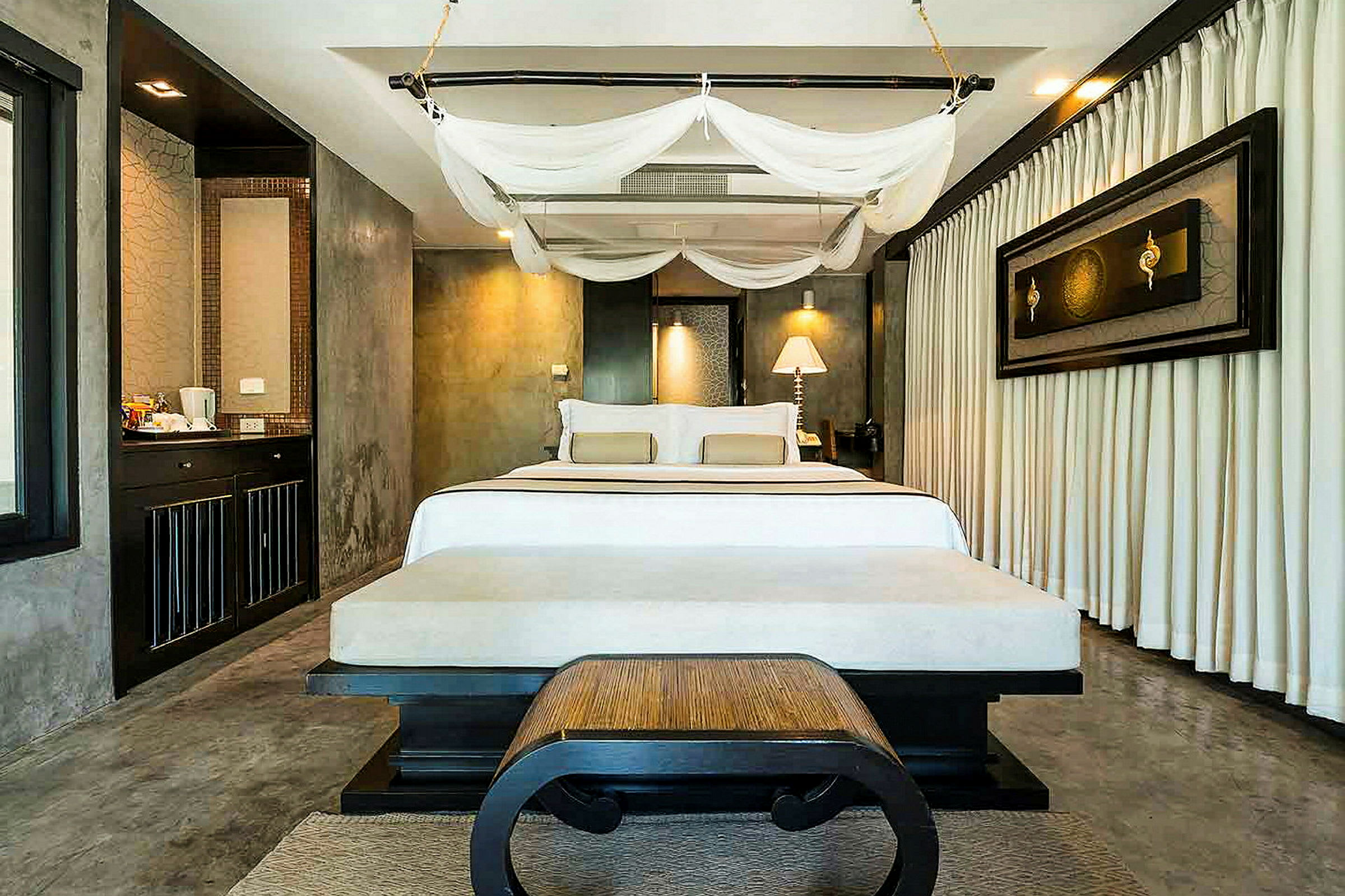Ett hotellrum med en dubbelsäng, myggnät och elegant inredning. (AI-genererad text)