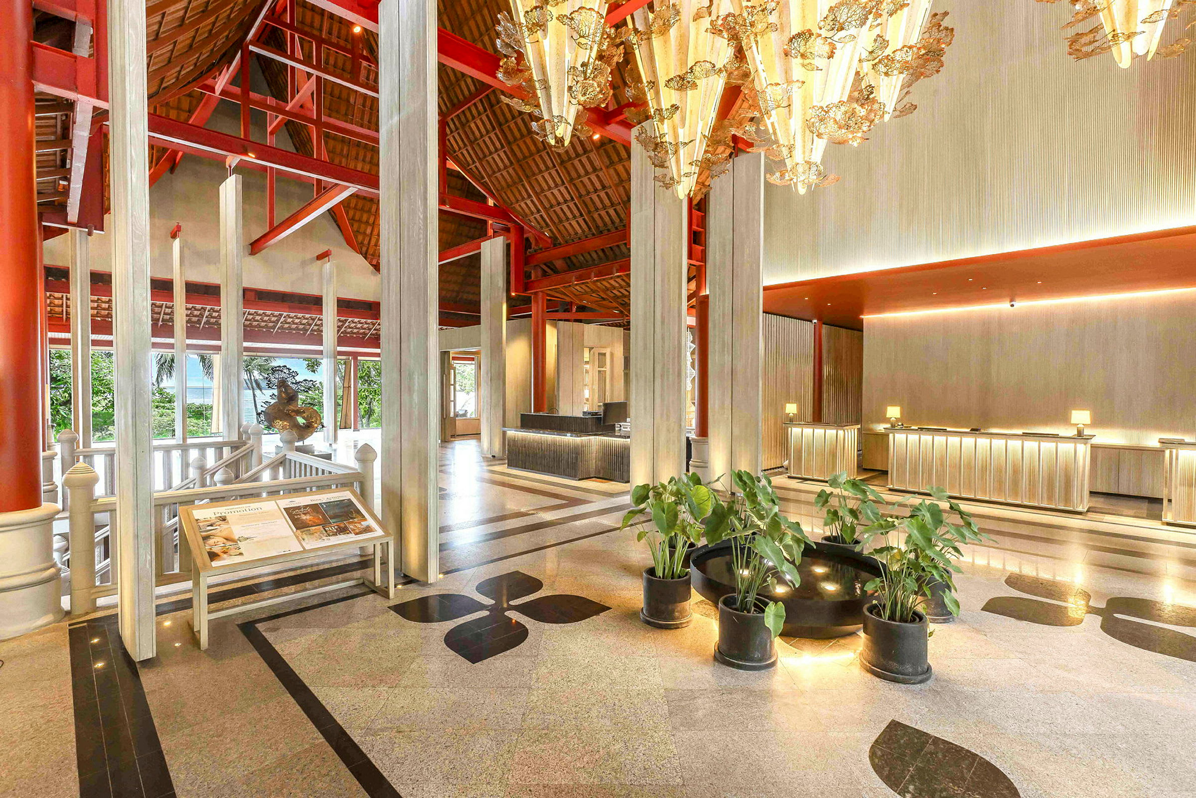 Bild av en hotellreception med modern inredning, högt tak, ljuskronor och växter. (AI-genererad text)