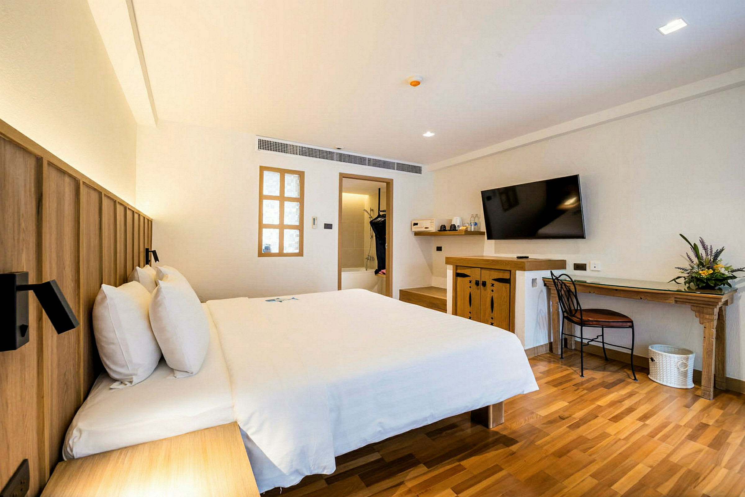 Ett hotellrum med en stor säng, en TV på väggen, och ett skrivbord med en stol. (AI-genererad text)