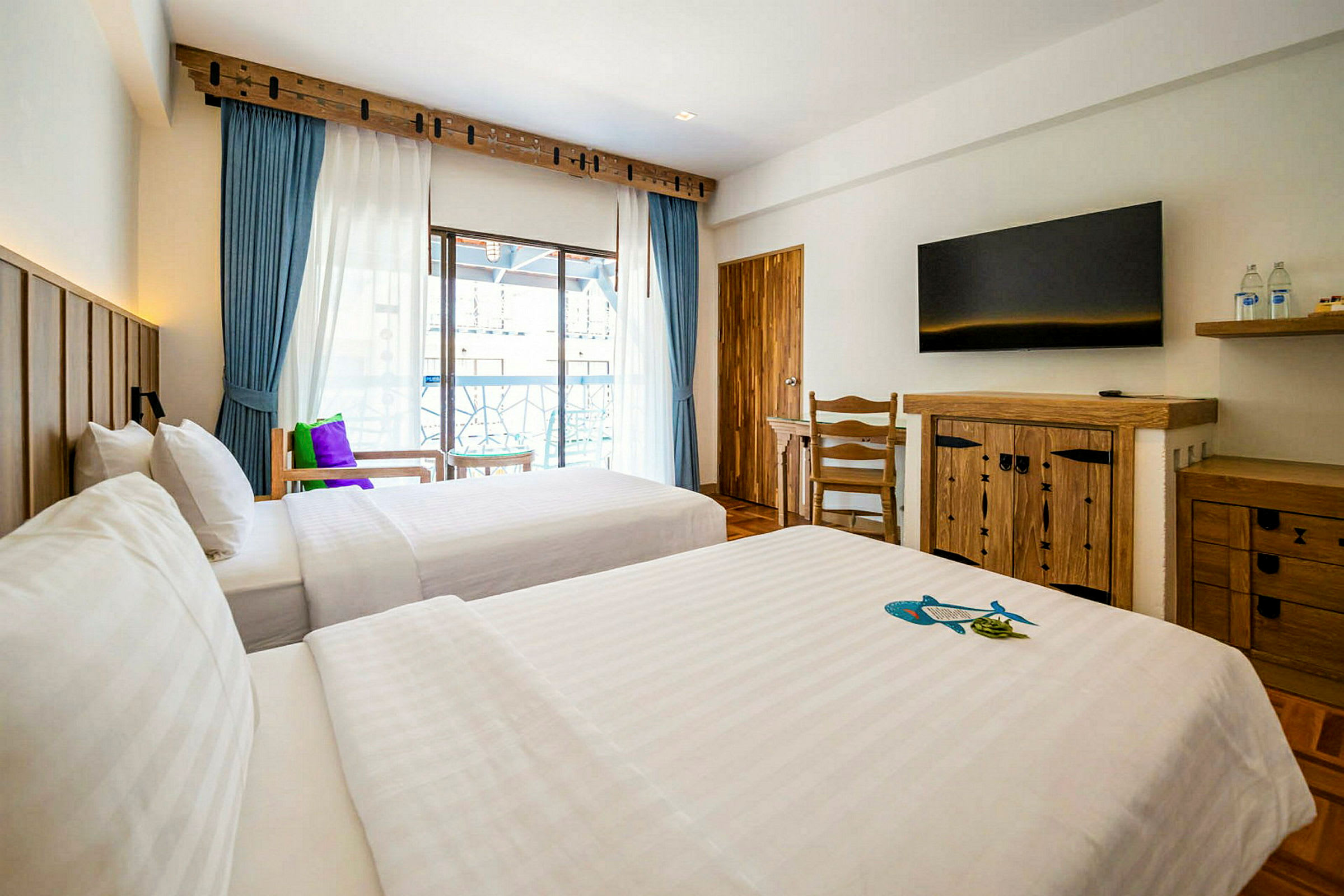 Två separata sängar i ett hotellrum med träinredning och fönster mot balkongen. (AI-genererad text)