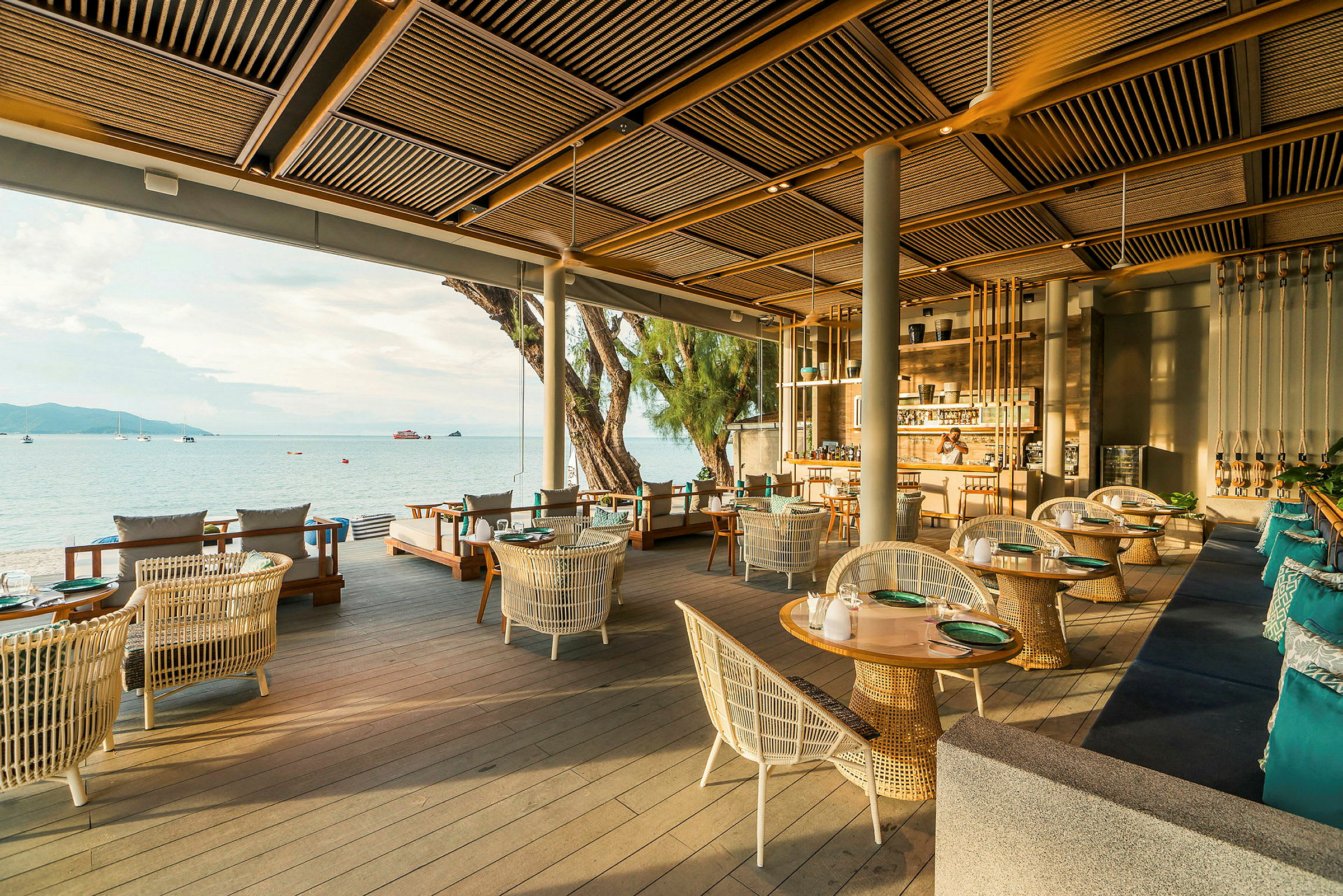 En elegant restaurang med utsikt över havet, inredd med moderna möbler och utspridda bord och sittgrupper. (AI-genererad text)