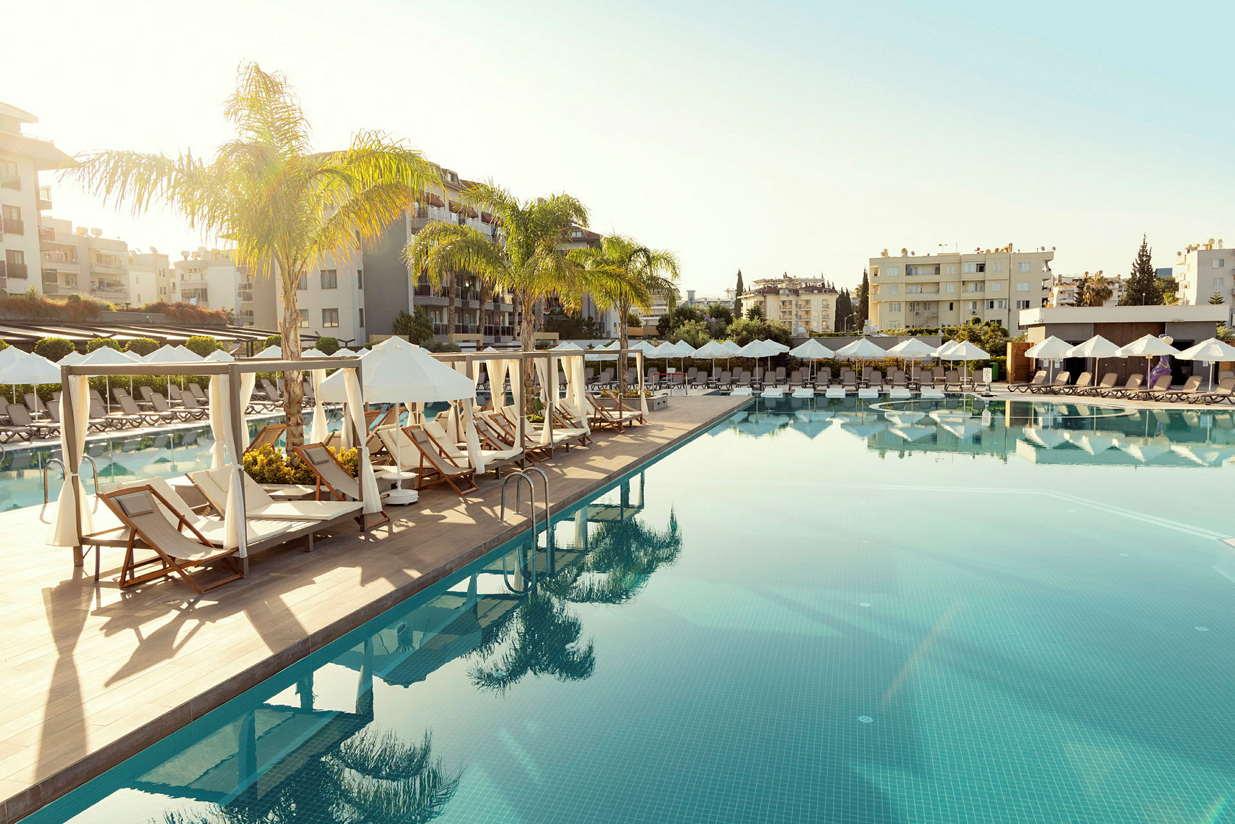 En pool med solstolar och parasoller i en resortmiljö. (AI-genererad text)
