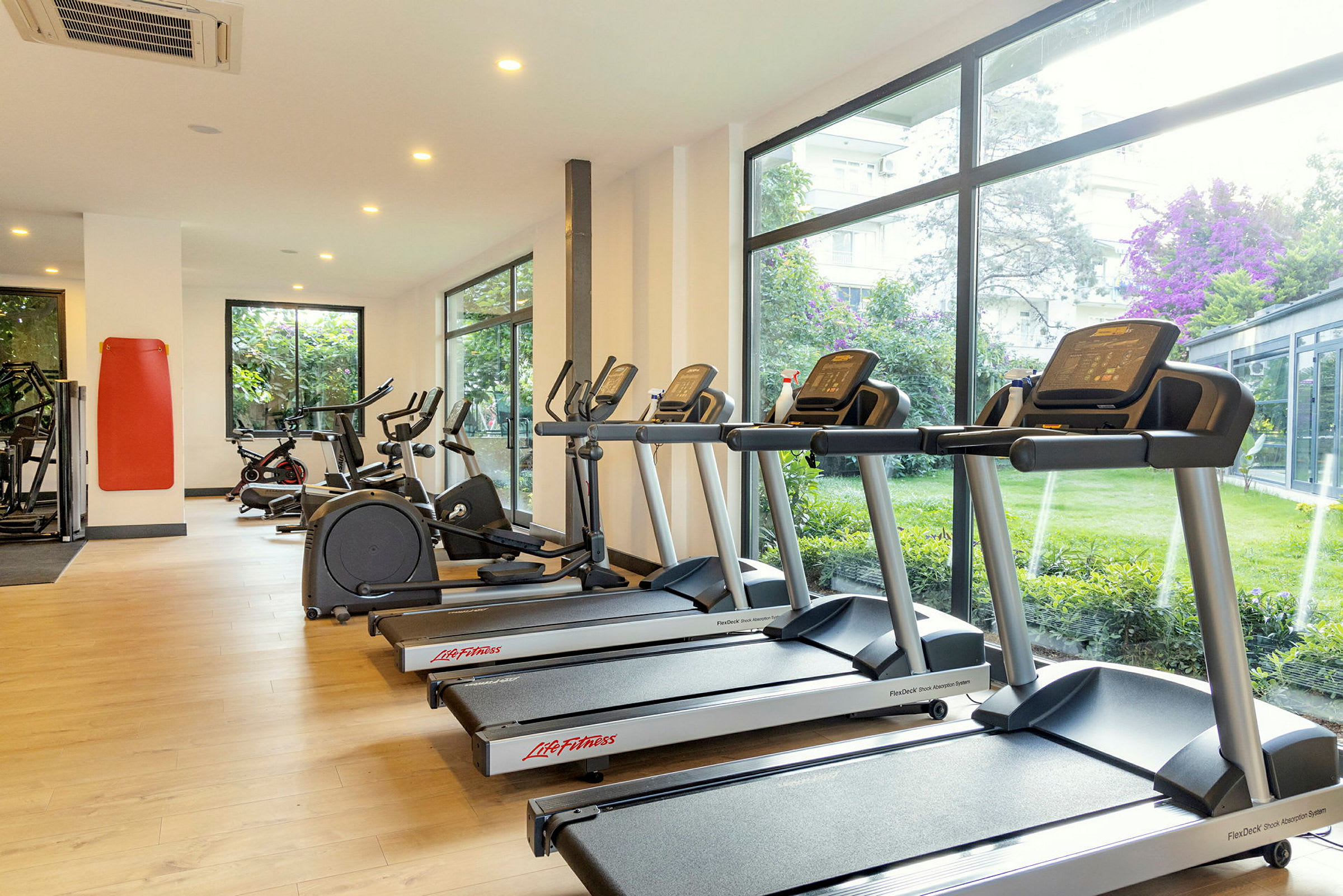 Gym med löpband och motionscyklar vid stora fönster. (AI-genererad text)
