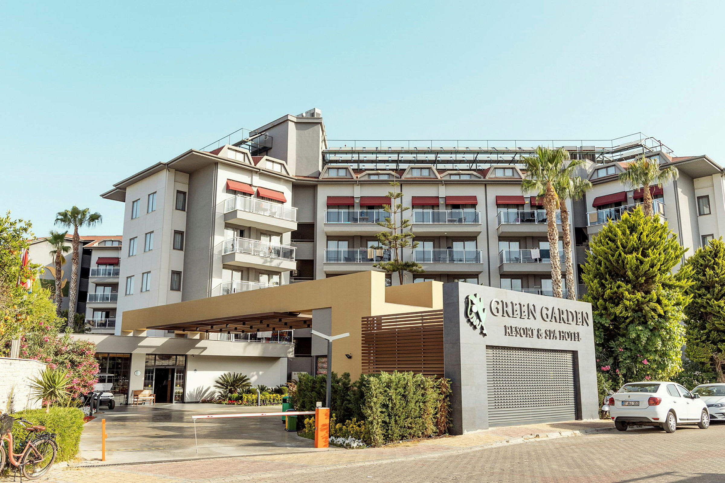 Exteriör av ett hotell med flera våningar och röda markiser. (AI-genererad text)