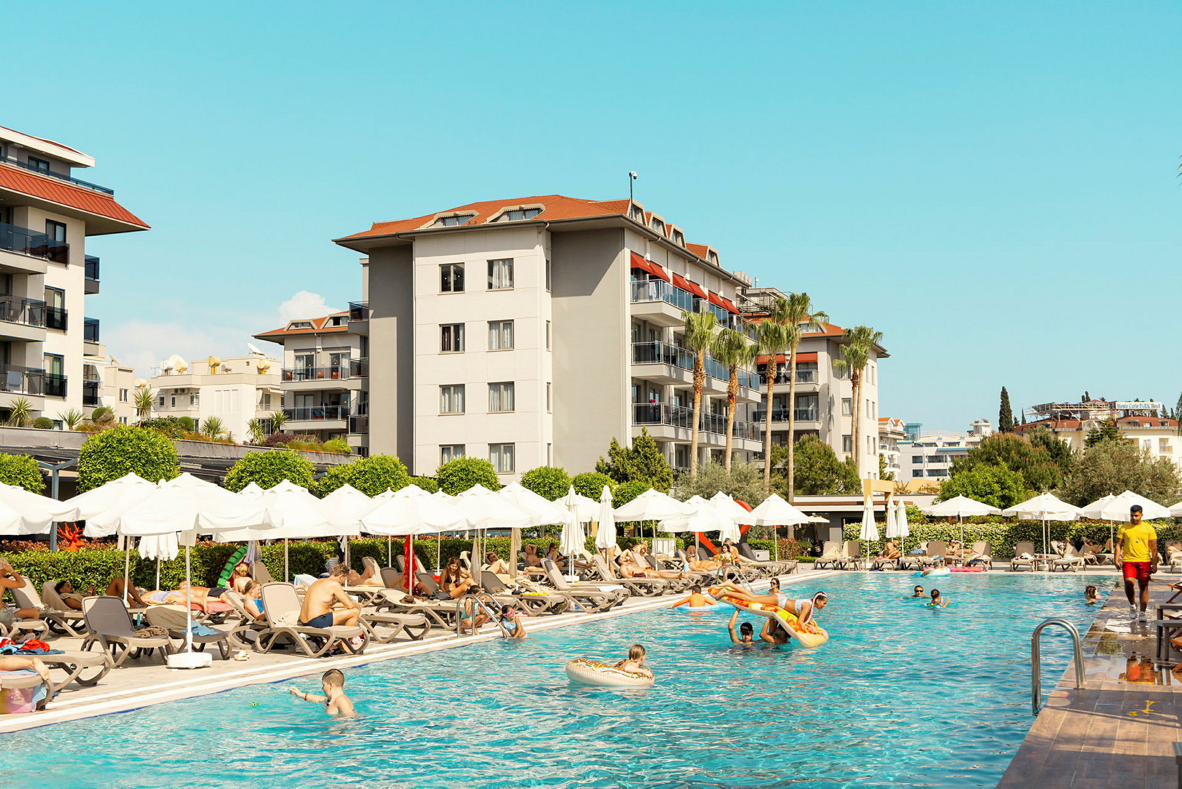 Utomhuspoolområde vid hotell med solstolar och parasoller. (AI-genererad text)