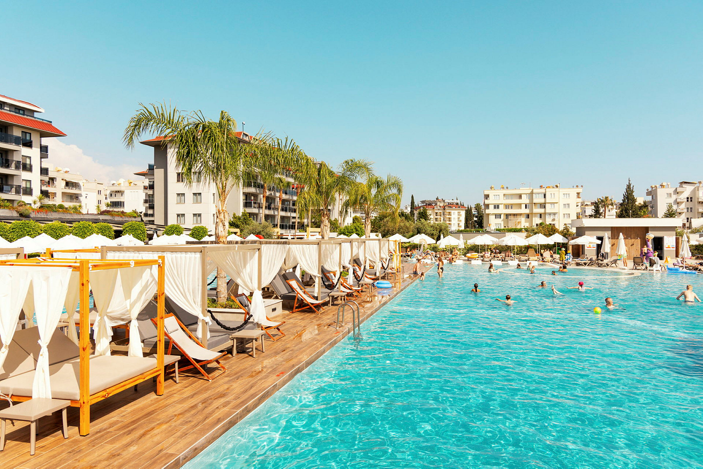 Utomhuspool med solstolar och parasoller vid ett hotell. (AI-genererad text)