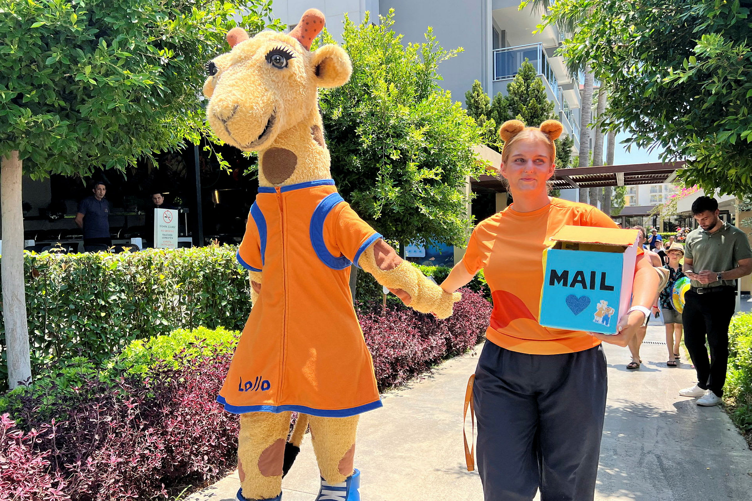 En person klädd som en giraff i en orange kostym utomhus. (AI-genererad text)